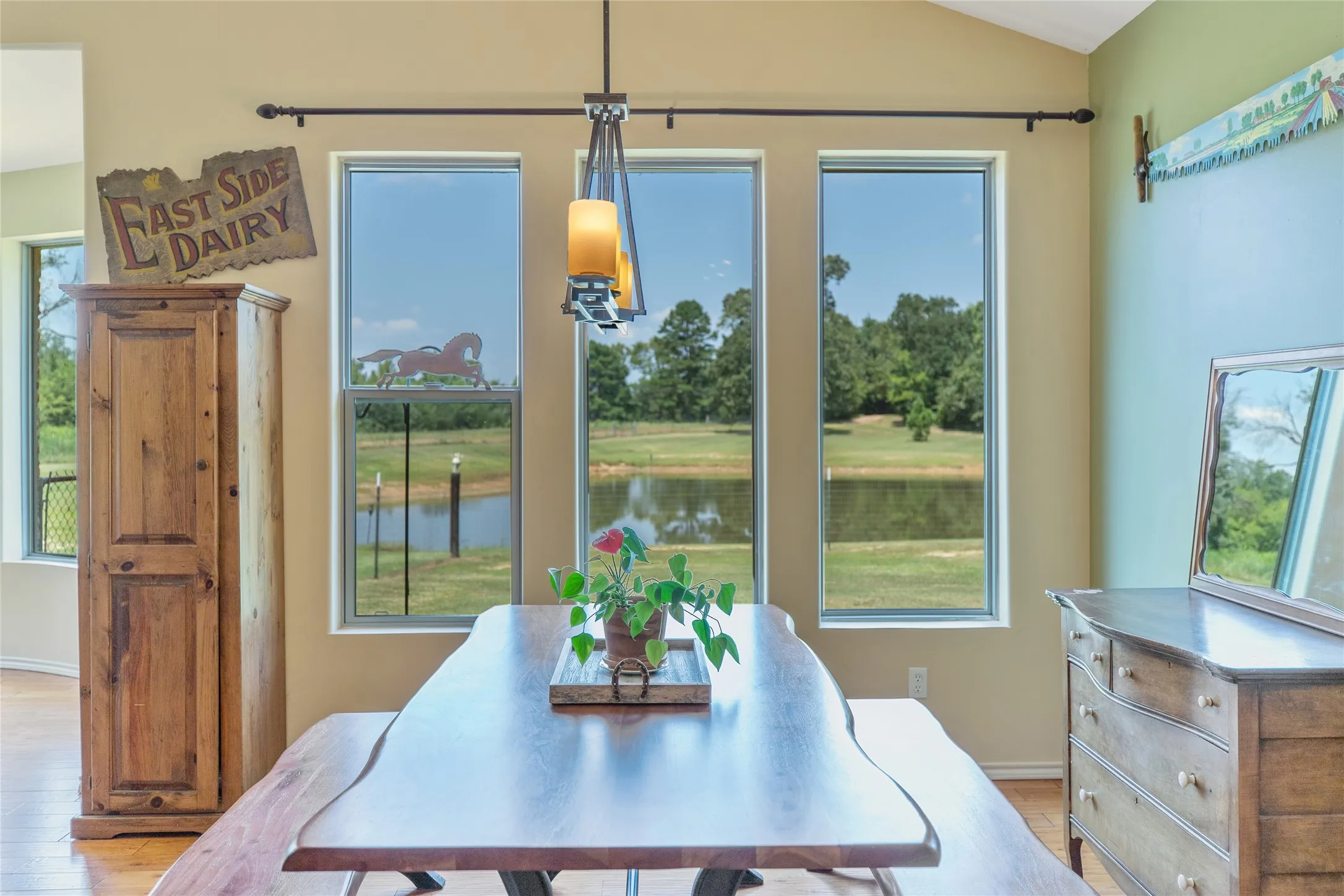 Cozy dining area featuring natural light, scenic outdoor views, and custom wood style flooring.