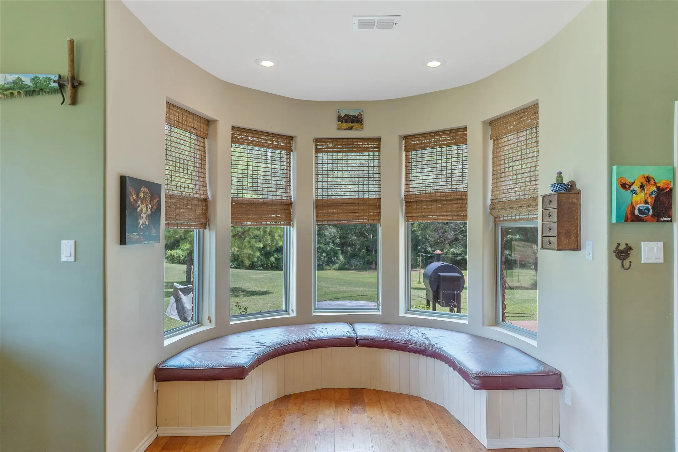 Unique curved alcove sunroom area with a built in window bench overlooking the scenic acreage.