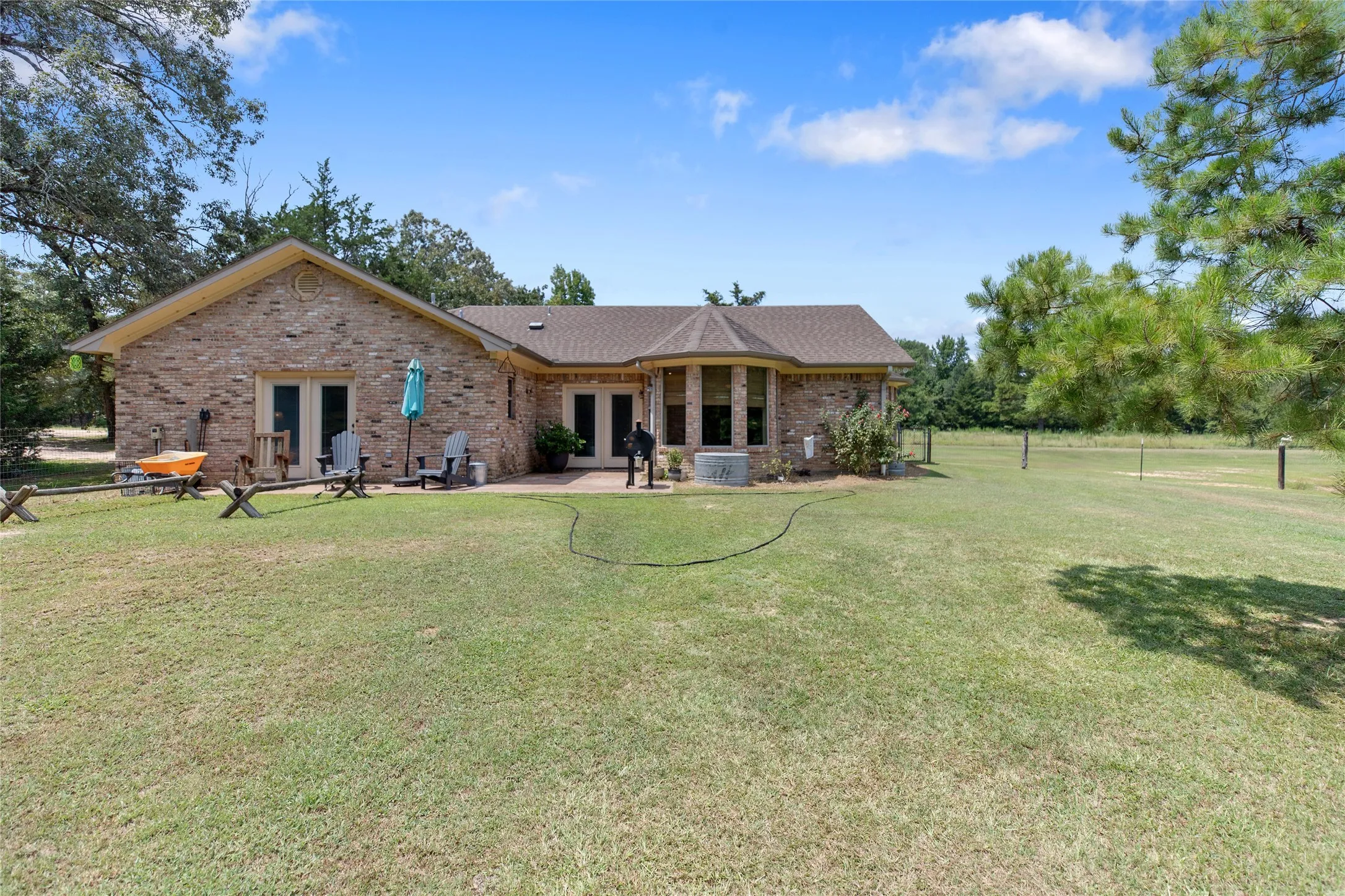 Back exterior view of the custom home highlighting the large windows and manicured grass.