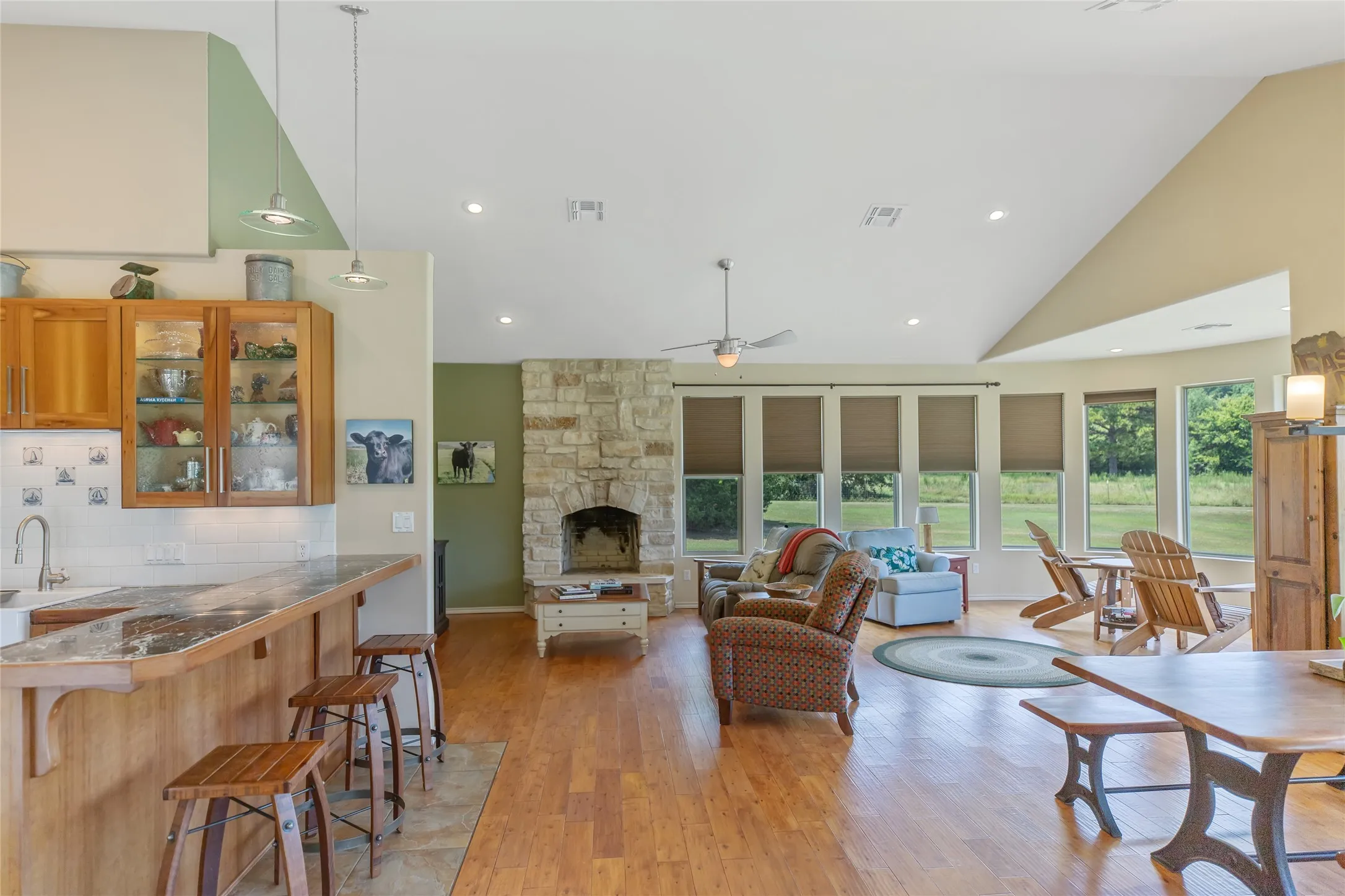 Wide angle view of the open living space showcasing custom flooring and the grand stone fireplace.