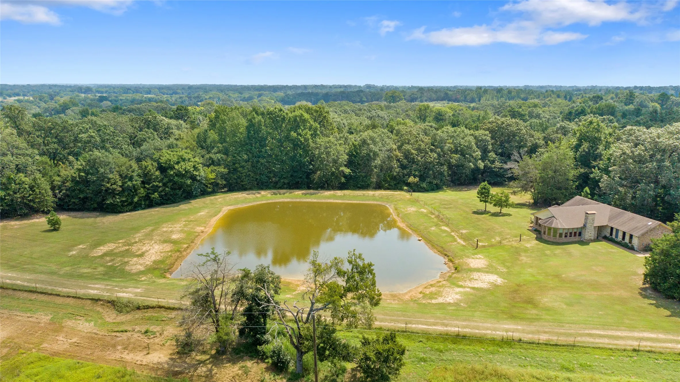 Birds eye view of the private half acre stock pond and surrounding acreage in Winnsboro TX.