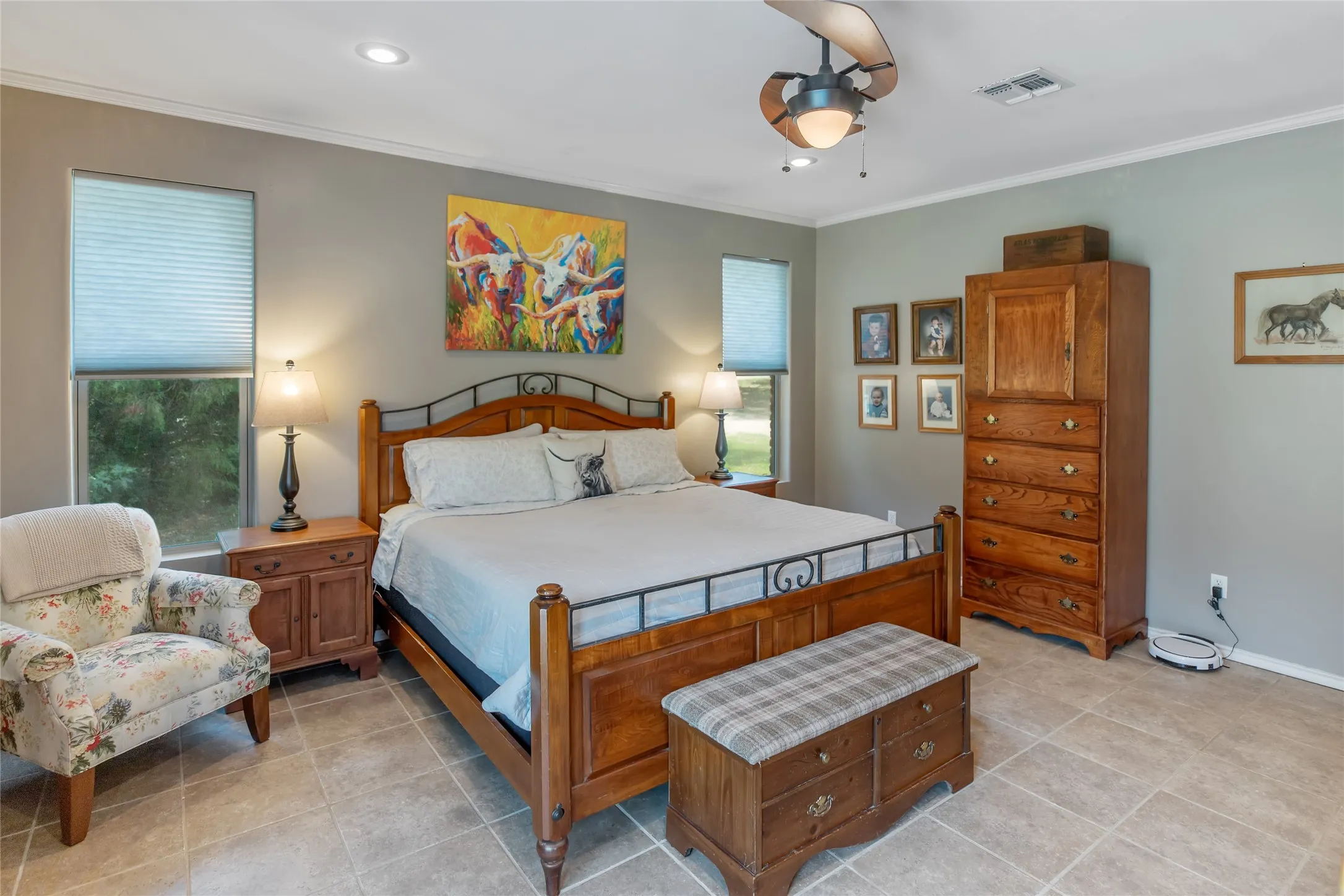 Large master bedroom featuring crown molding, neutral paint, and beautiful wood furniture.