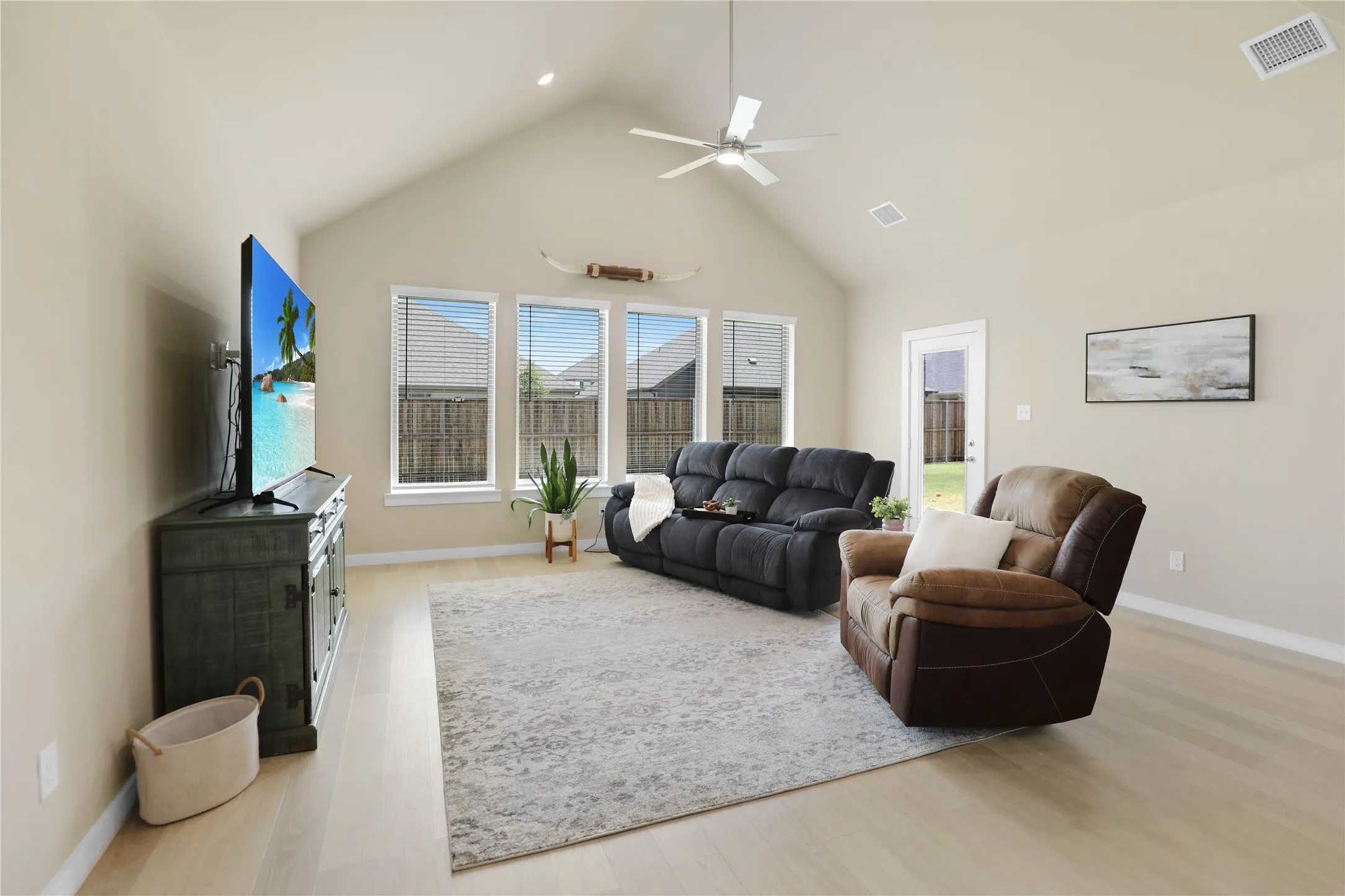 Vaulted ceiling great room featuring wood-finish flooring, recessed lighting, and a ceiling fan