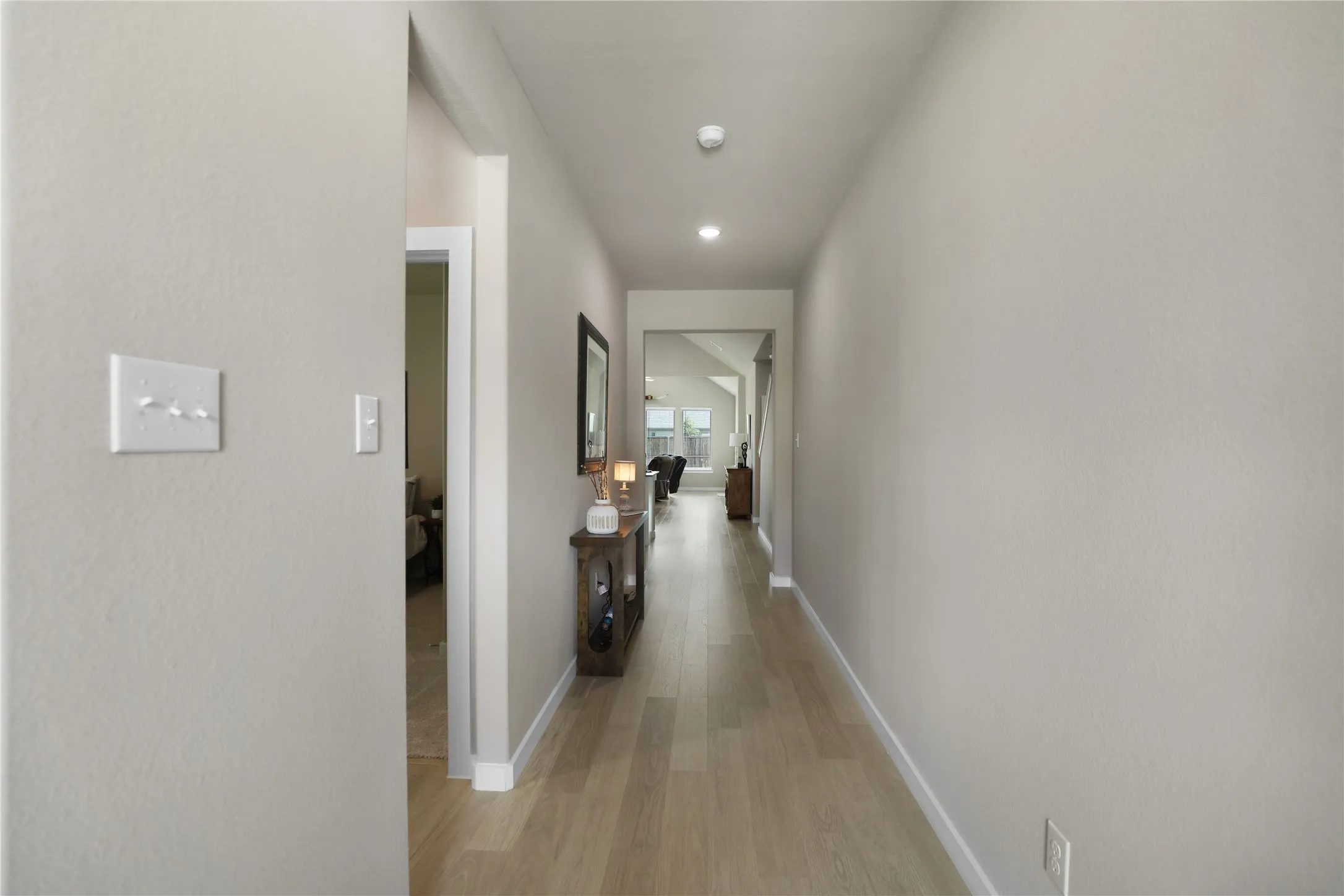 Hallway featuring light-toned wood-finish flooring, recessed lighting, and neutral wall paint