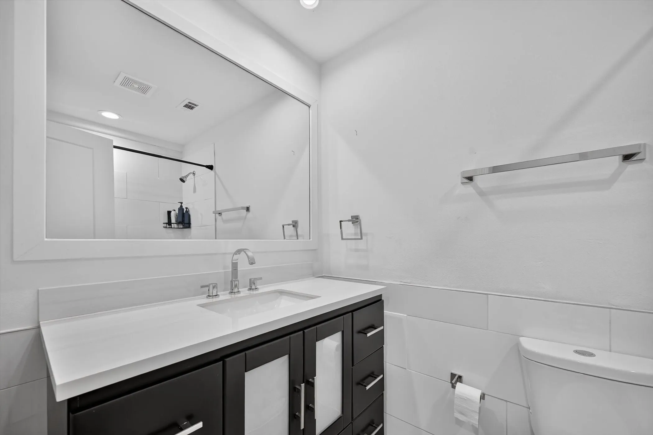 Bathroom featuring a dark wood-finish vanity with a light-toned countertop and an integrated sink