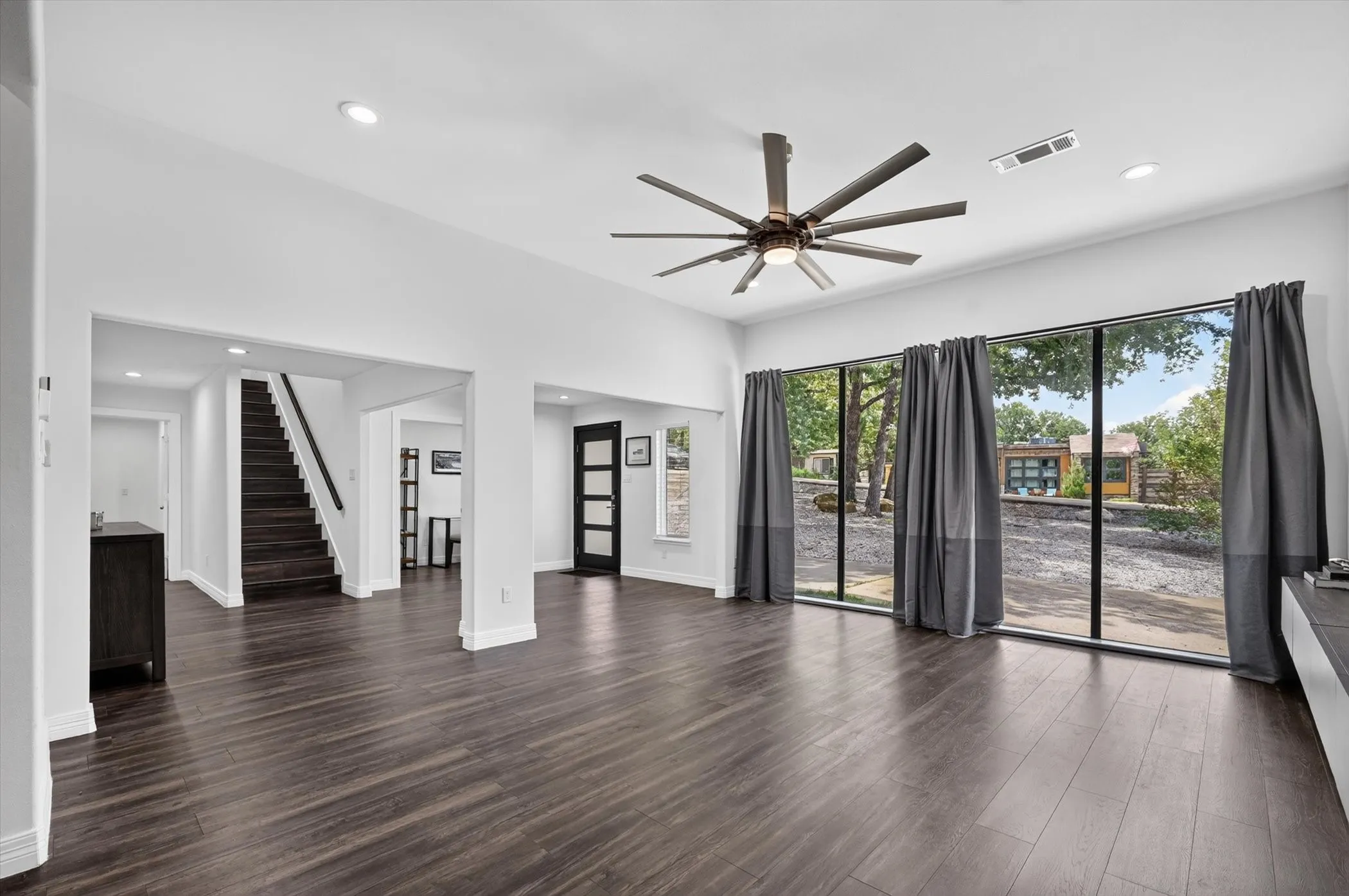 Spacious interior featuring dark wood-finish flooring, recessed lighting, and a contemporary ceiling fan