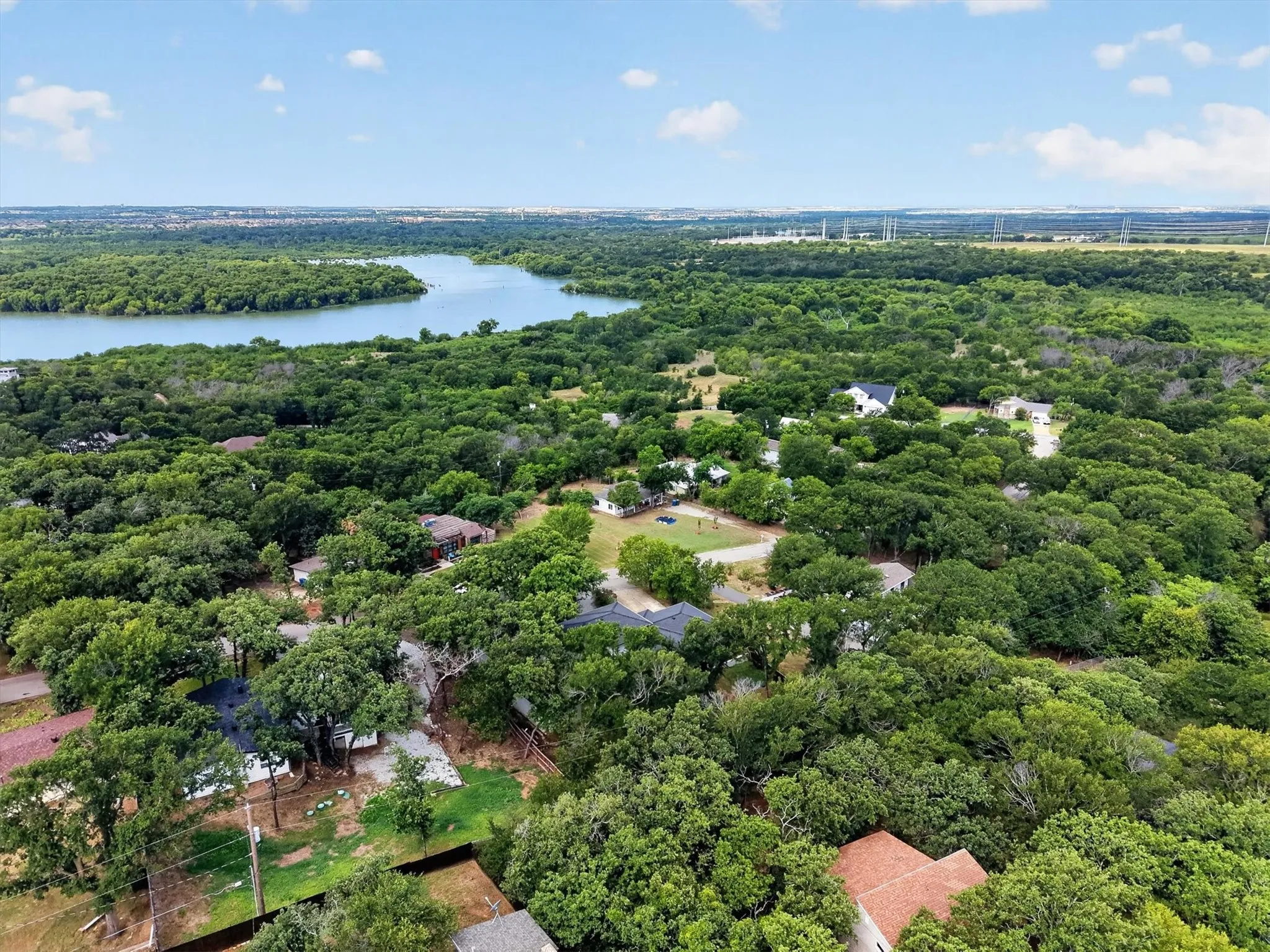 Aerial perspective showcasing a serene lake surrounded by extensive mature tree coverage
