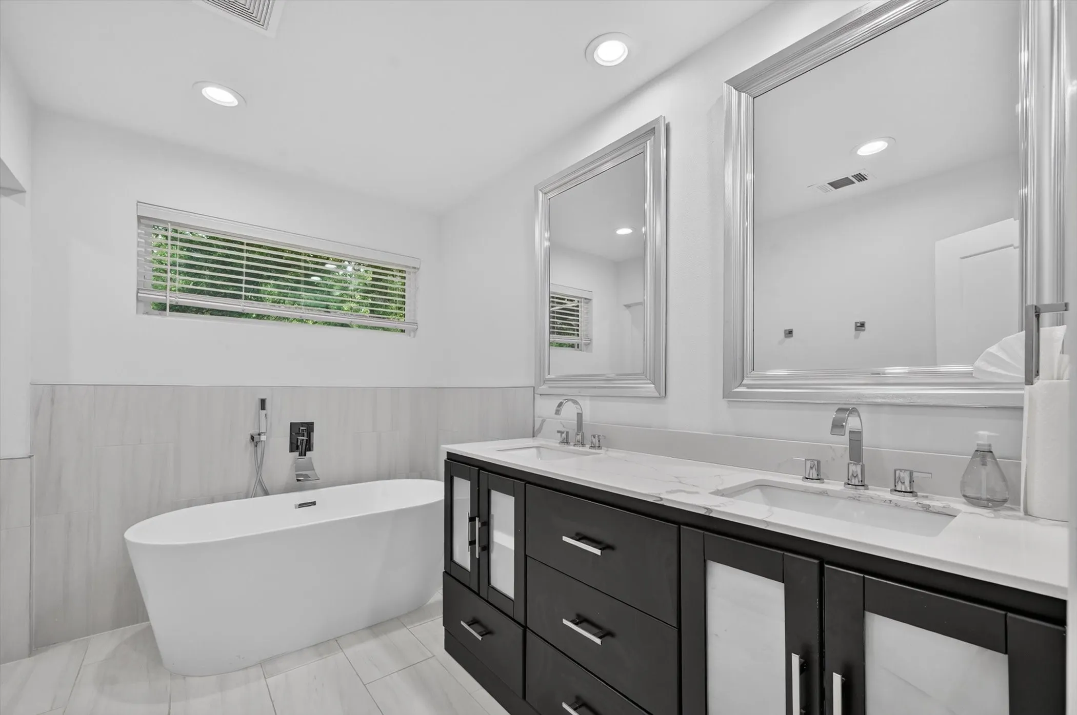 Freestanding soaking tub with wall-mounted fixtures