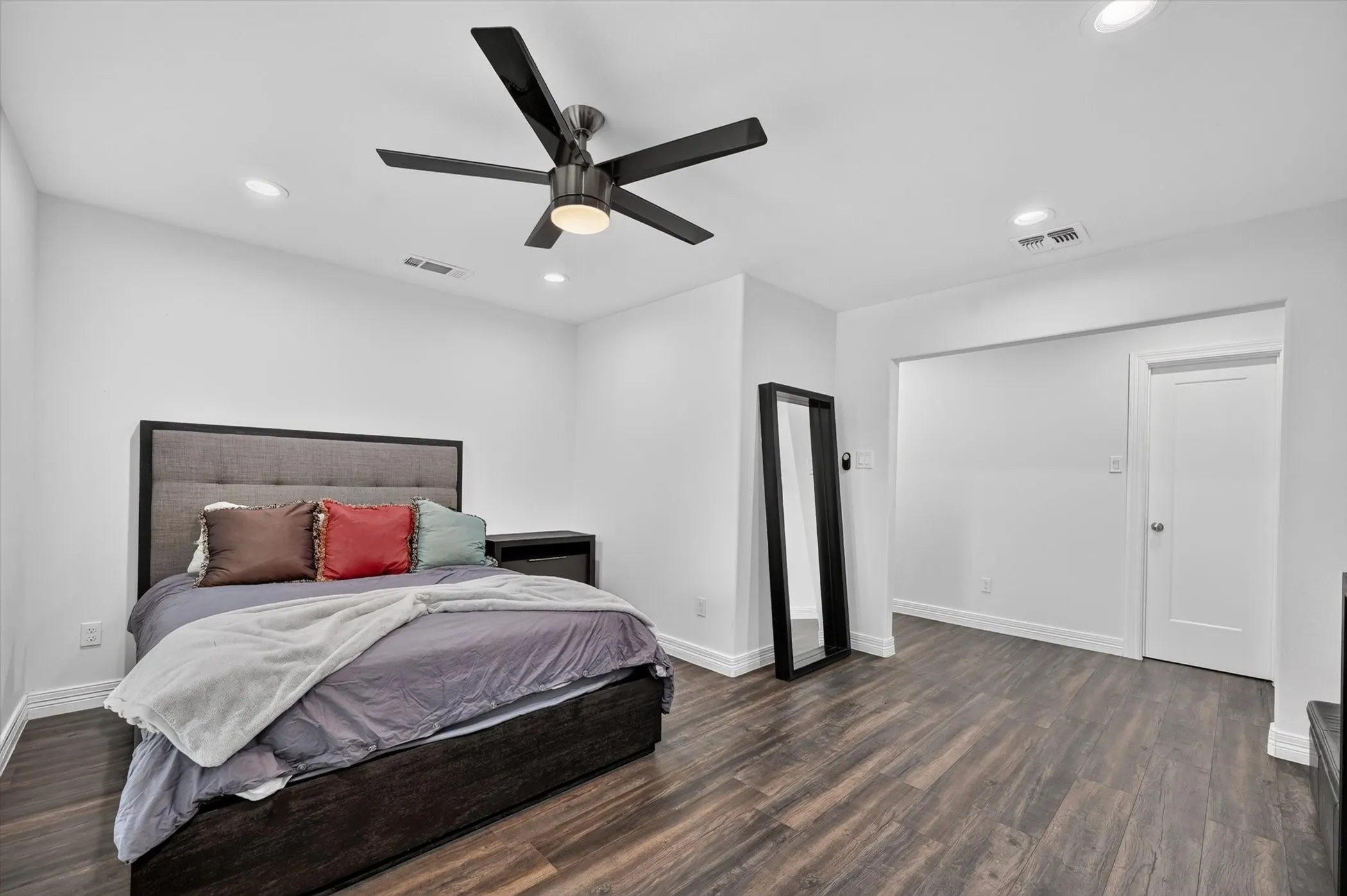Spacious room featuring wood-finish flooring, recessed lighting, and a modern ceiling fan