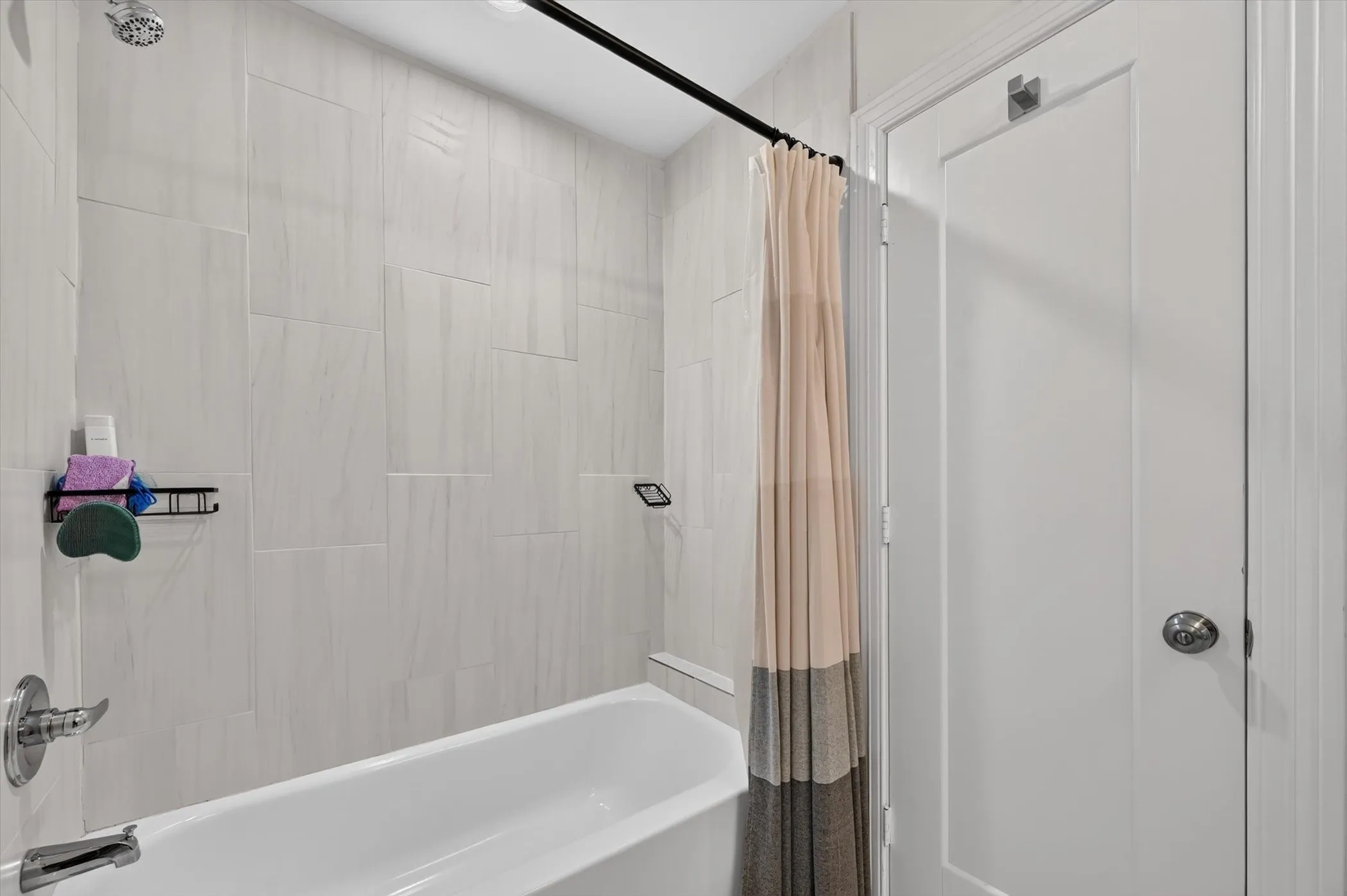 Bathtub and shower combination featuring large format wall tiling