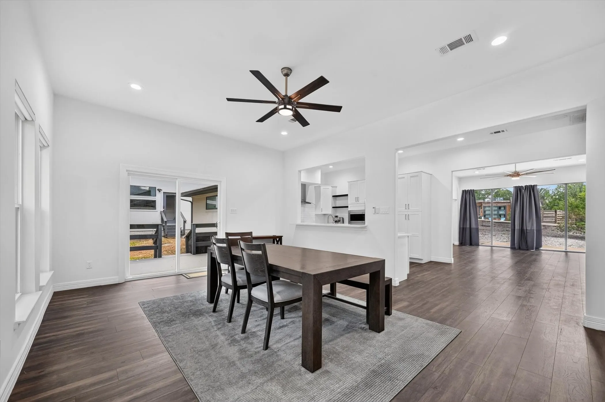 Open-concept dining area featuring wood-finish flooring, recessed lighting, and a modern ceiling fan