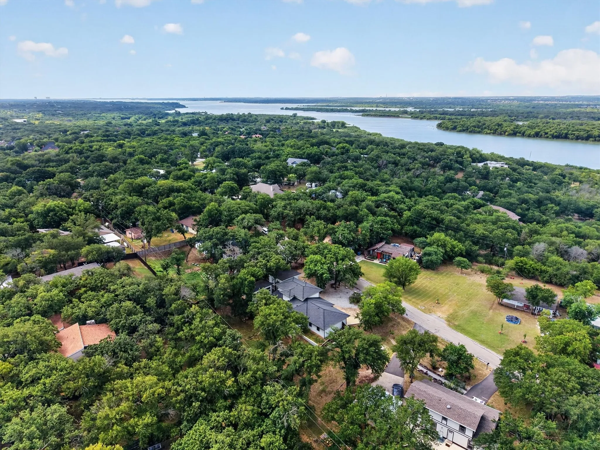 Expansive aerial perspective showcasing a residential area with a prominent body of water in the distance