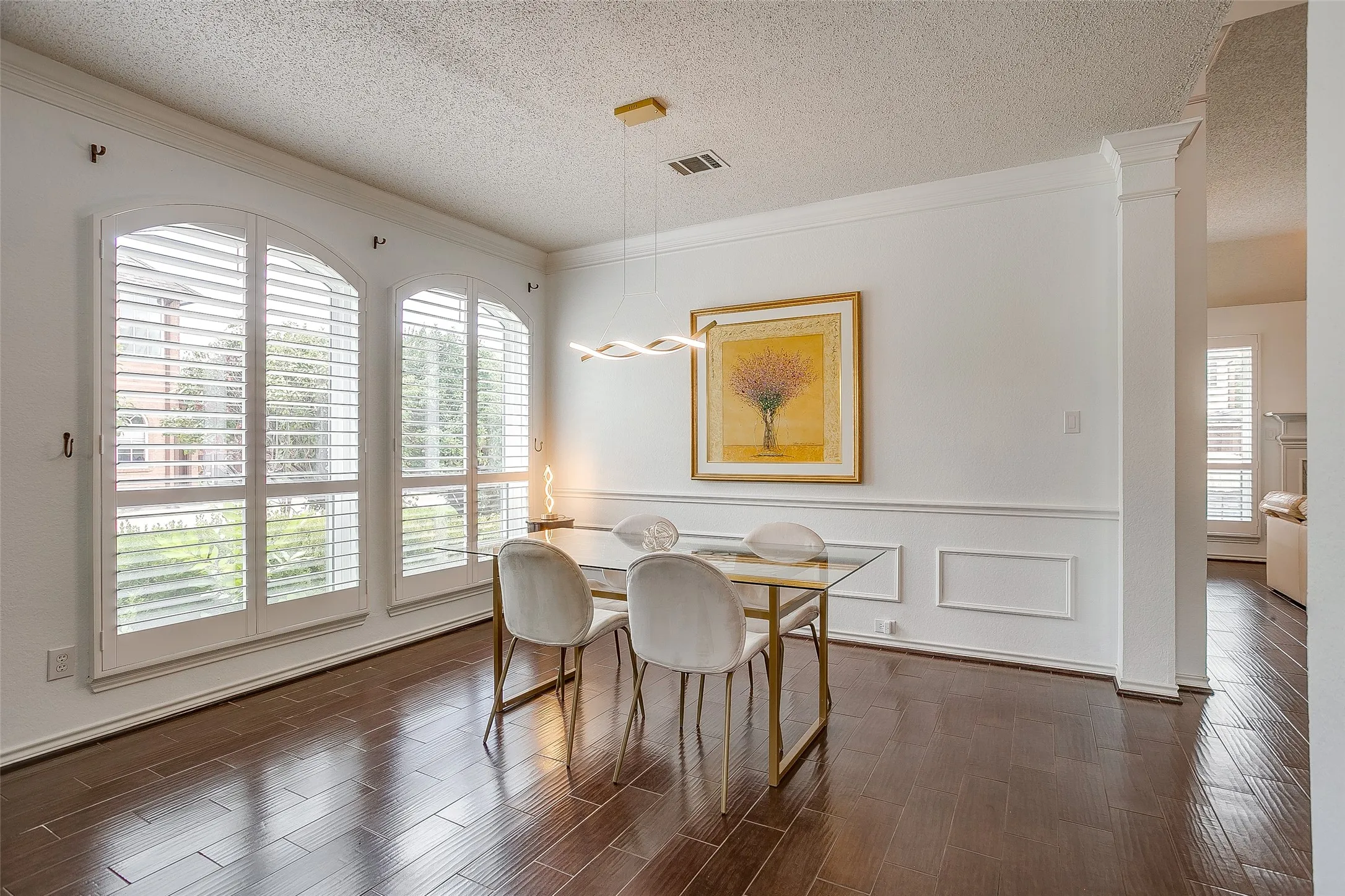 Designer touches with custom lighting, shutters and beautiful wainscoting in the formal dining area.