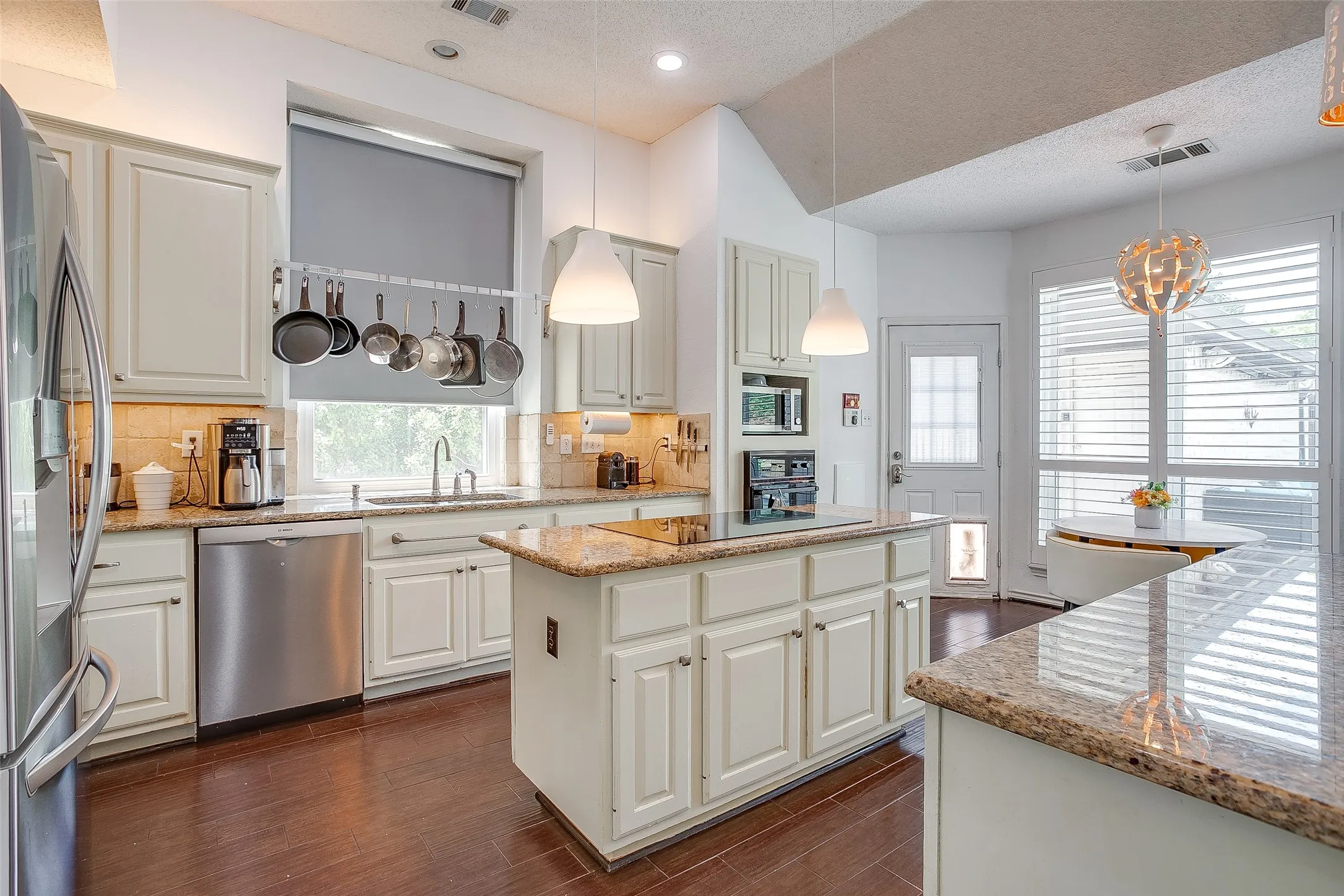 Custom pendant lighting above the breakfast bar, kitchen island and cabinetry.