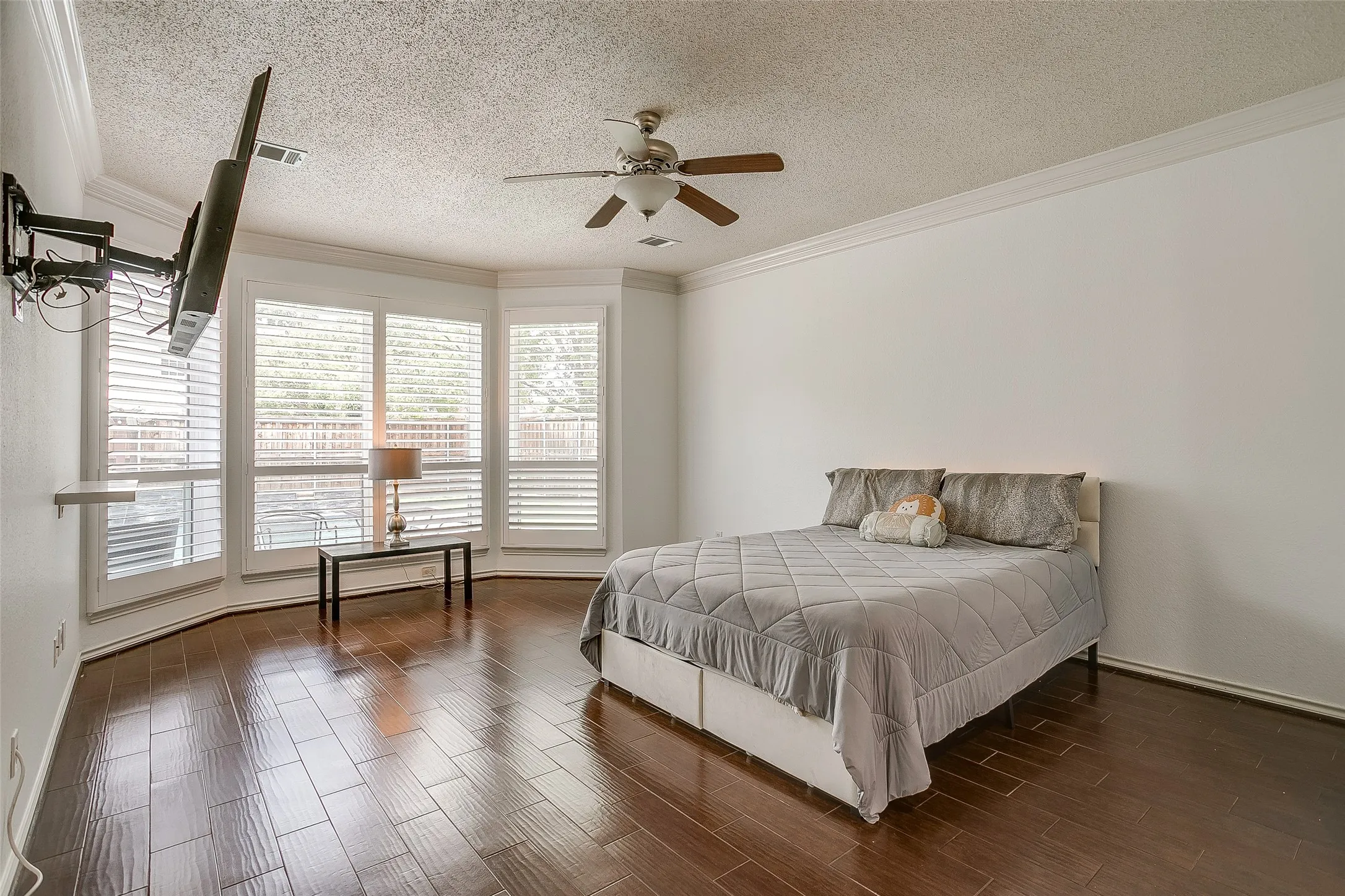 Spacious primary bedroom featuring bay windows and custom shutters looking out to your resort style pool.