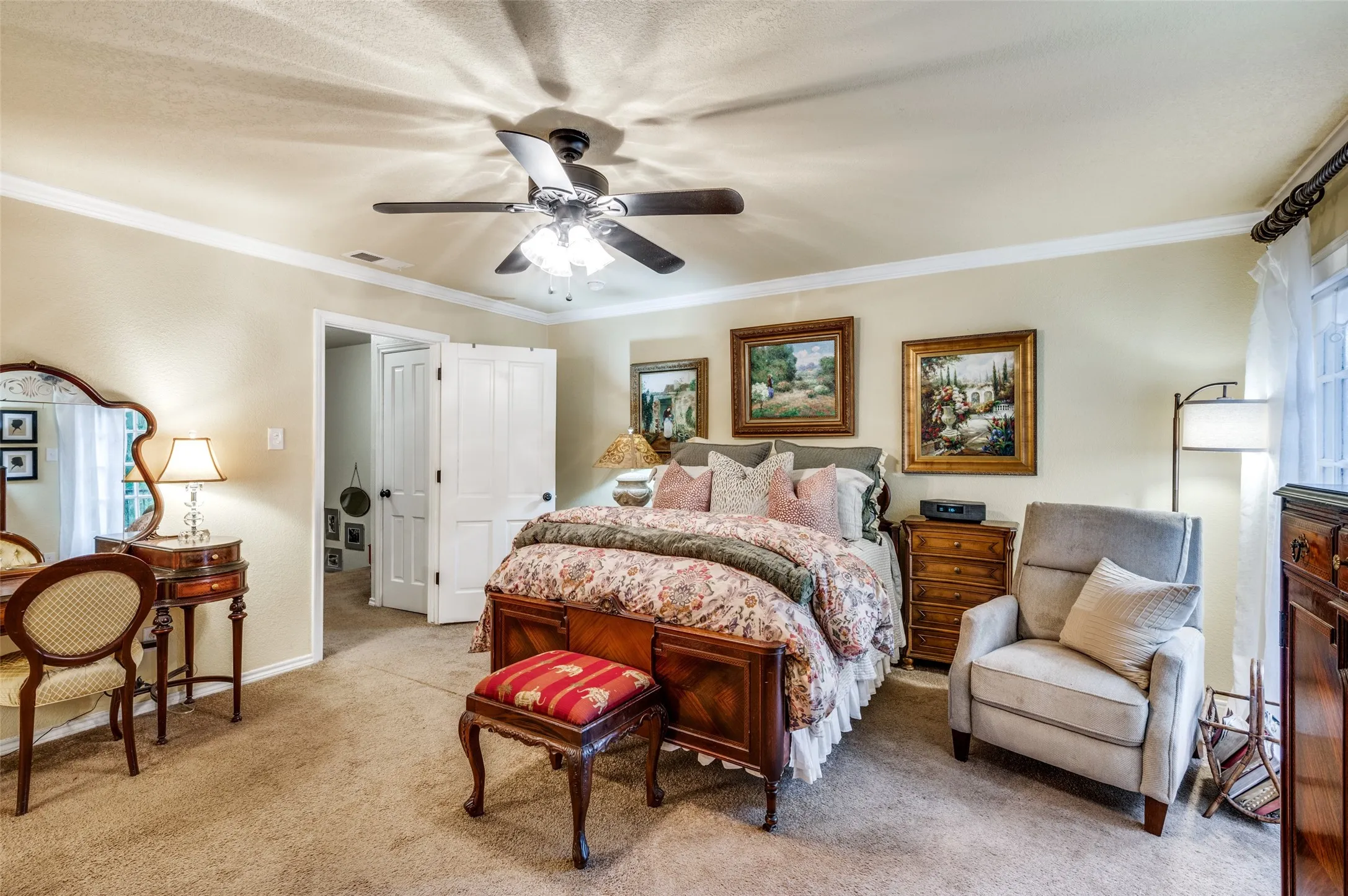 Primary Bedroom with Fren ceiling fan, and light carpet