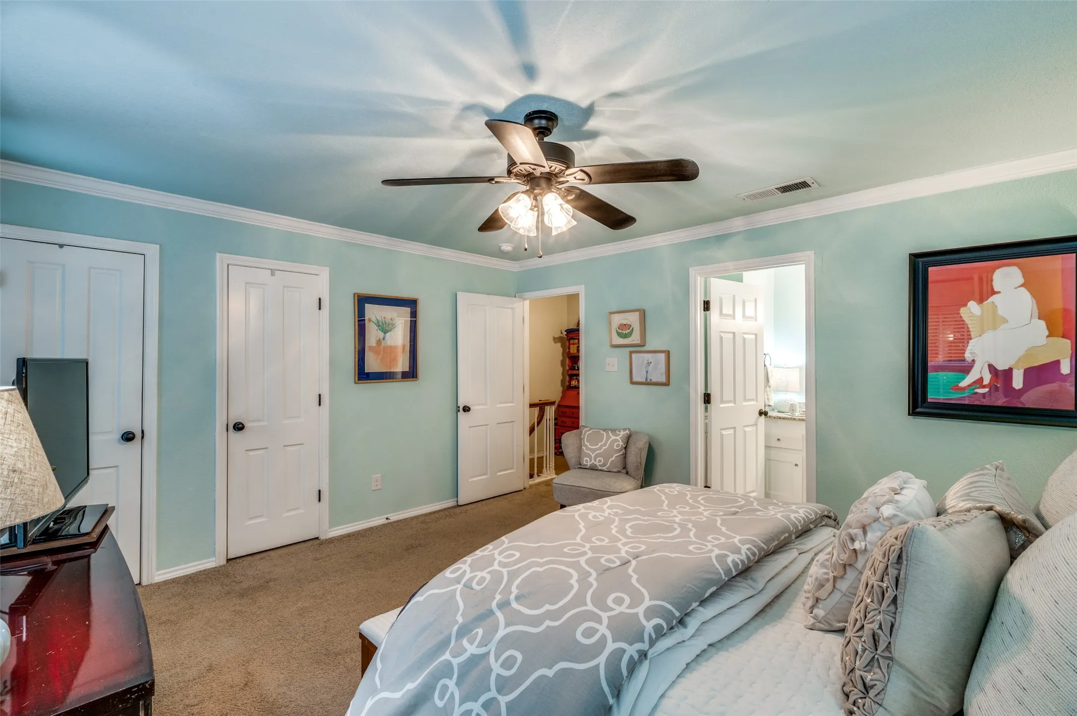 Bedroom featuring ceiling fan, ornamental molding, connected bathroom, and carpet floors
