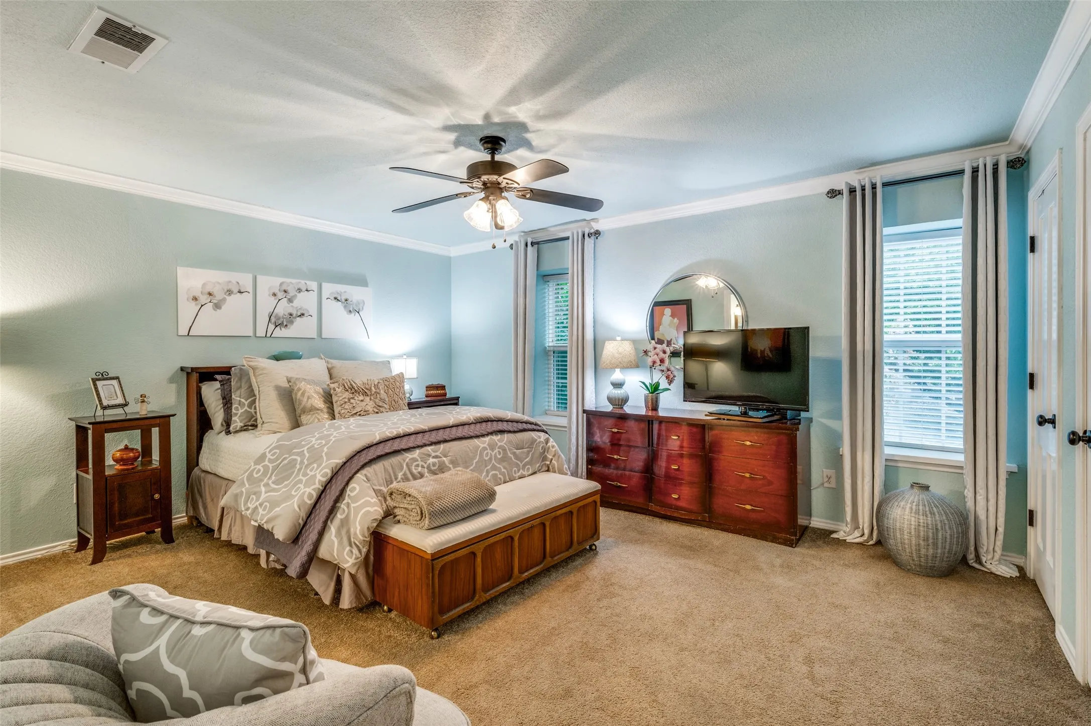 Carpeted bedroom featuring ceiling fan, a textured ceiling, and ornamental molding