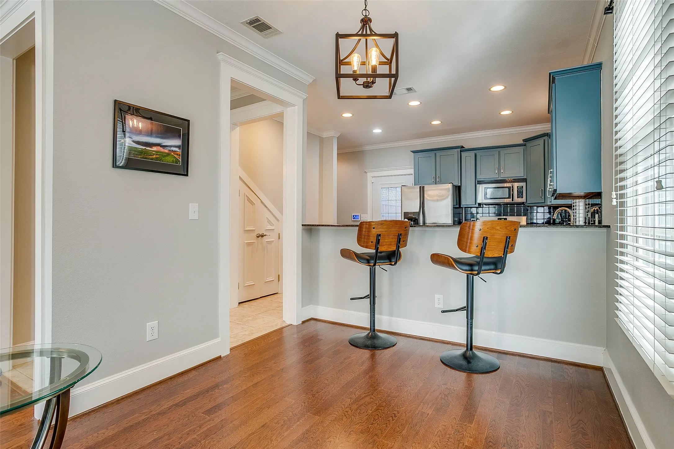 Kitchen bar area featuring wood-finish flooring, a pendant light fixture, and recessed lighting