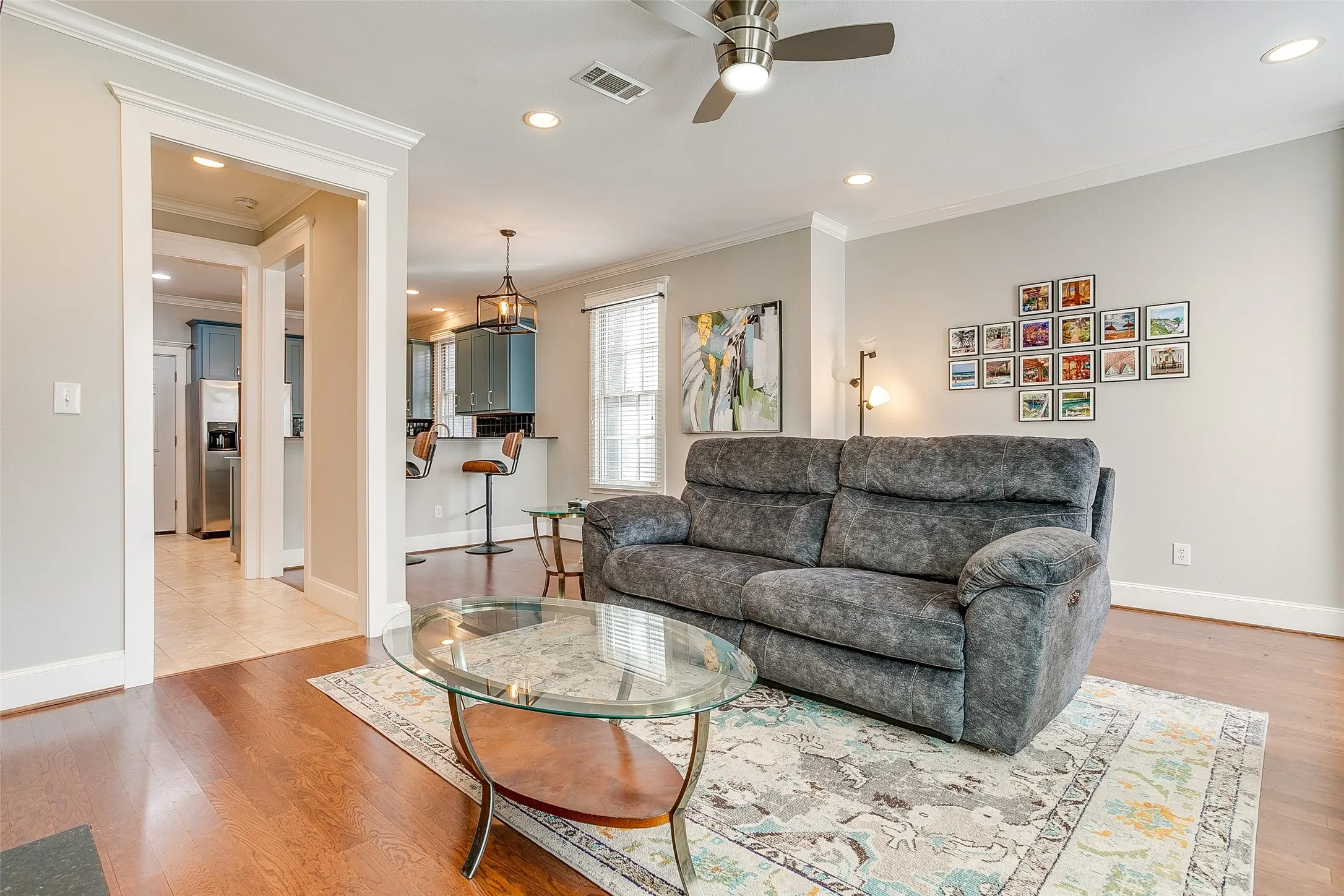 Open-concept living area featuring rich wood-finish flooring, recessed lighting, and a ceiling fan