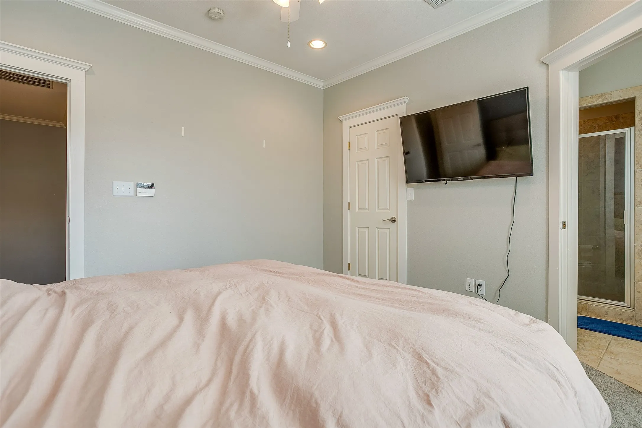 Spacious room featuring light-colored walls, crown molding, and recessed lighting
