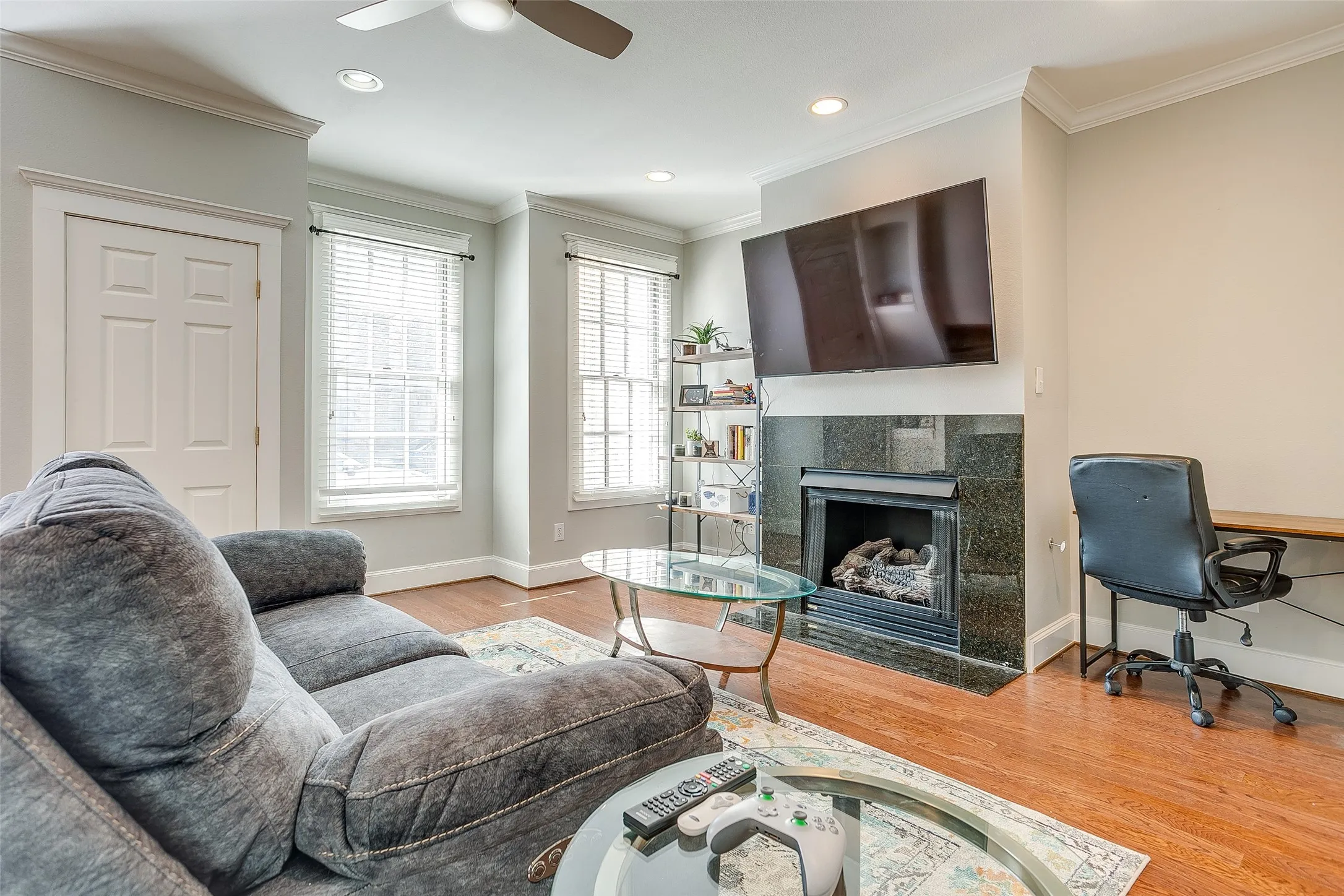 Living area featuring wood-finish flooring and a ceiling fan
