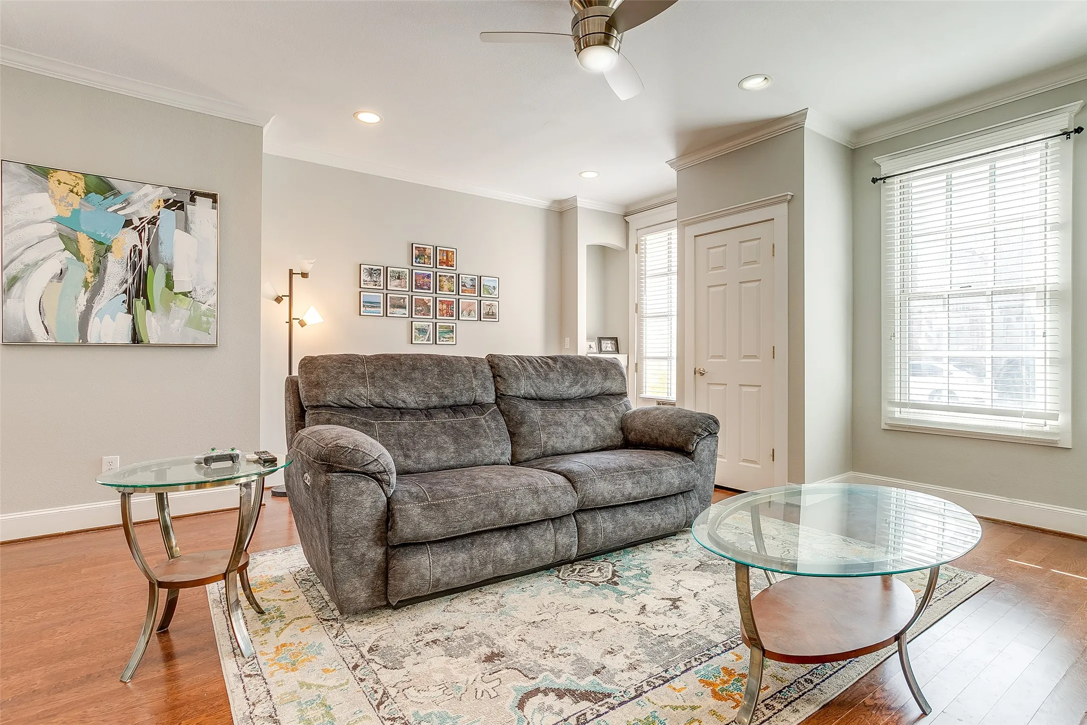 Living area featuring wood-finish flooring, a ceiling fan with integrated lighting, recessed lighting, and crown molding