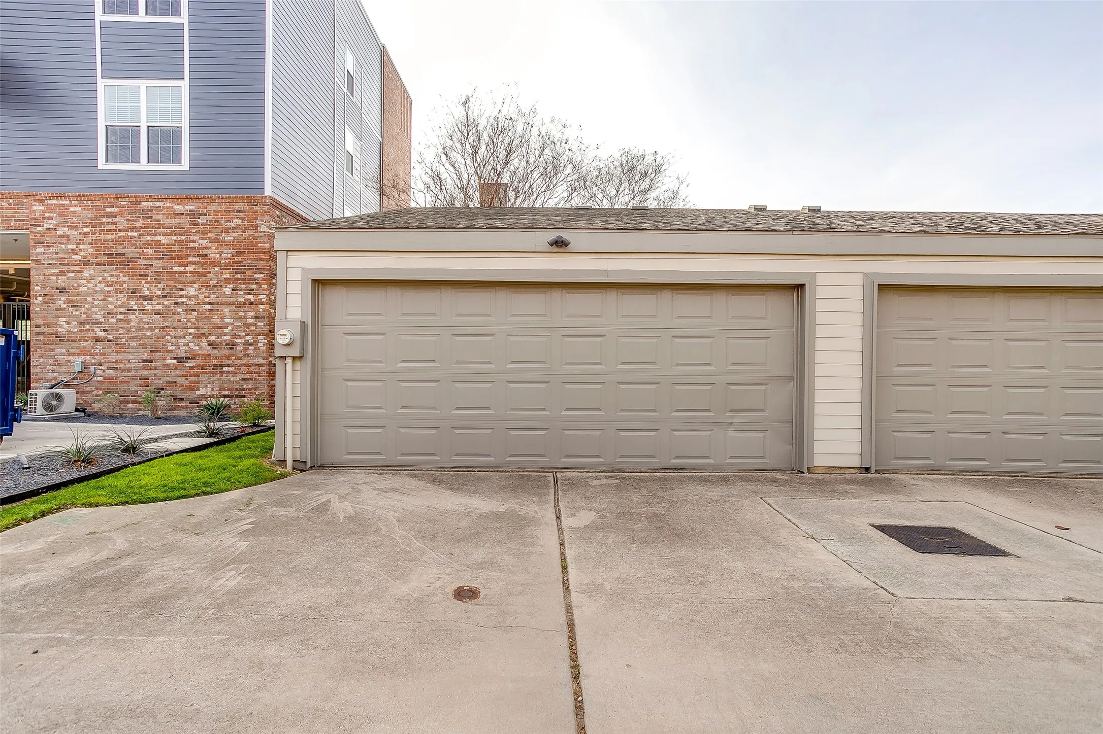 Two-car garage featuring panel-style doors and a shingled roofline
