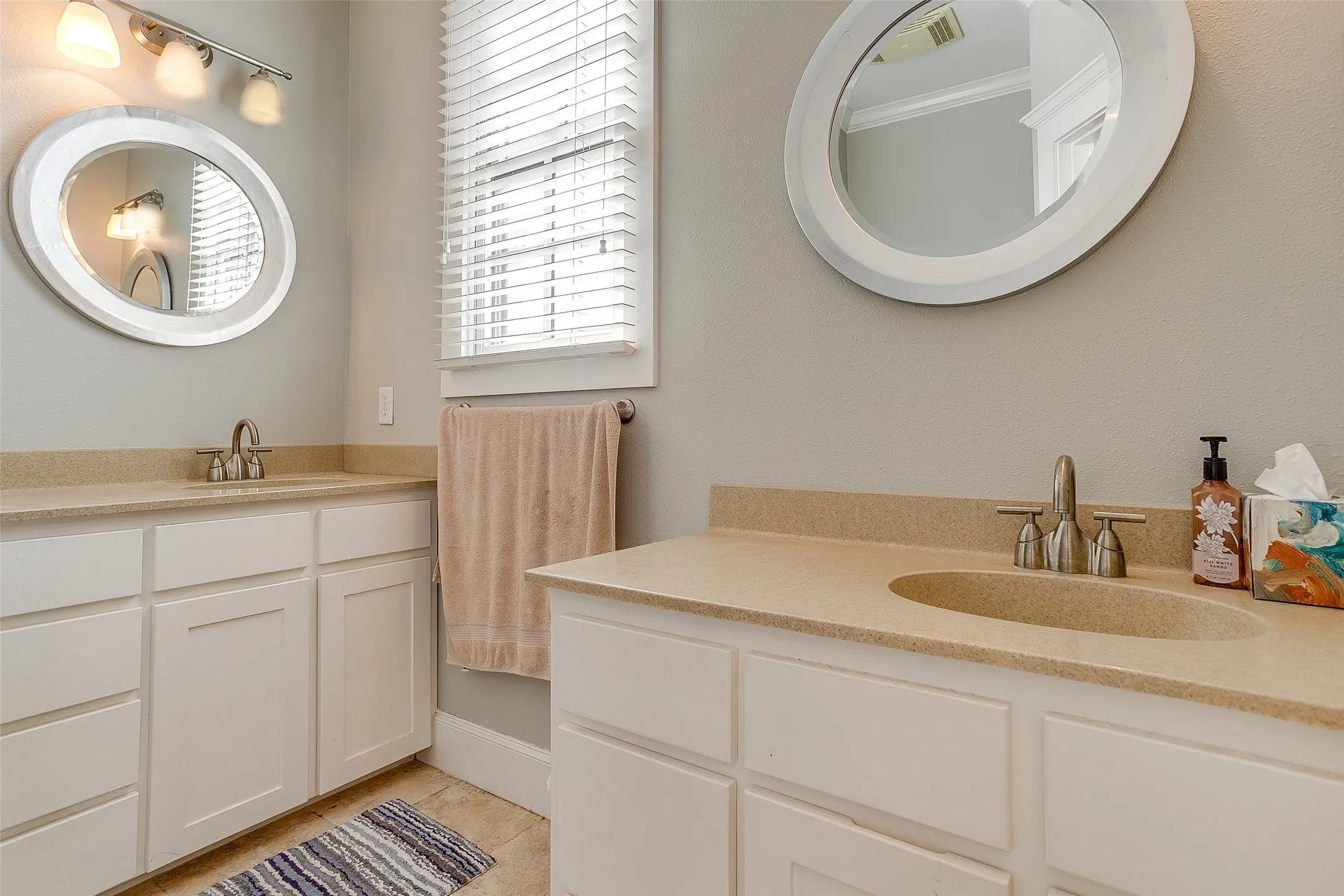 Dual vanity bathroom with light-toned countertops and integrated sinks