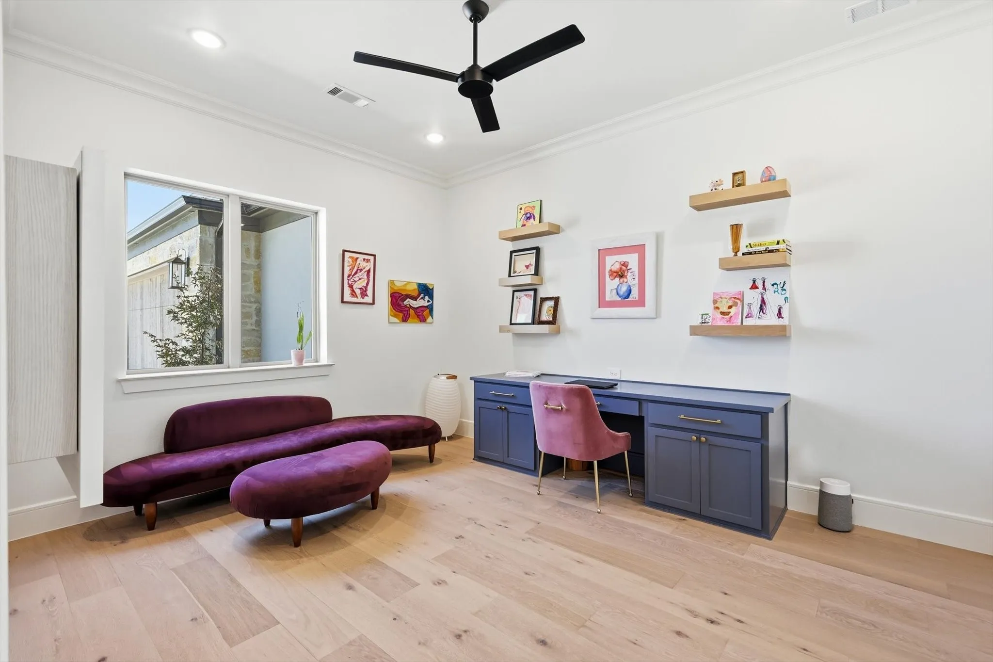 The office has a built-in desk and views of the front yard.