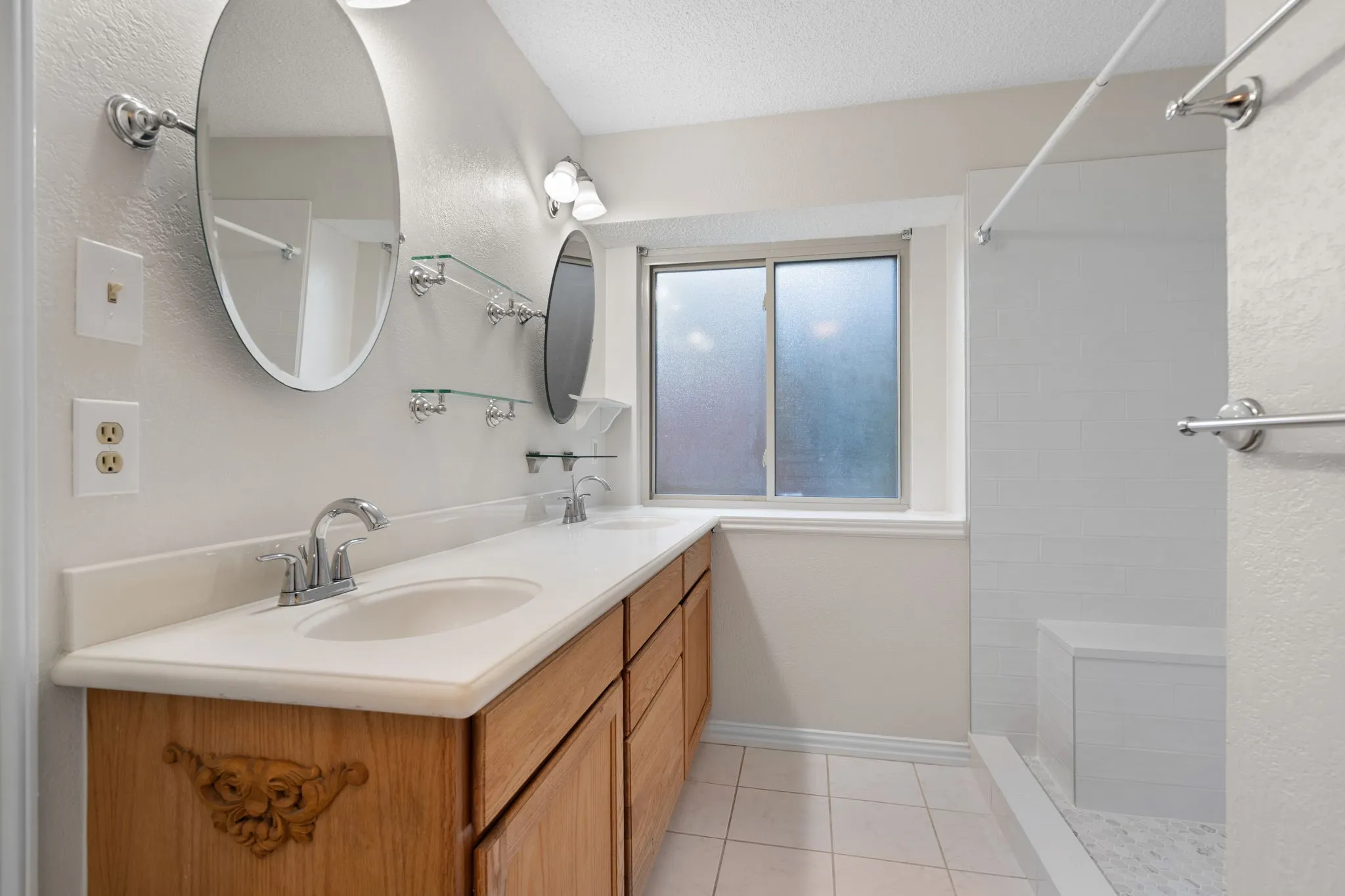 The primary bathroom has two sinks and a recently tiled shower.