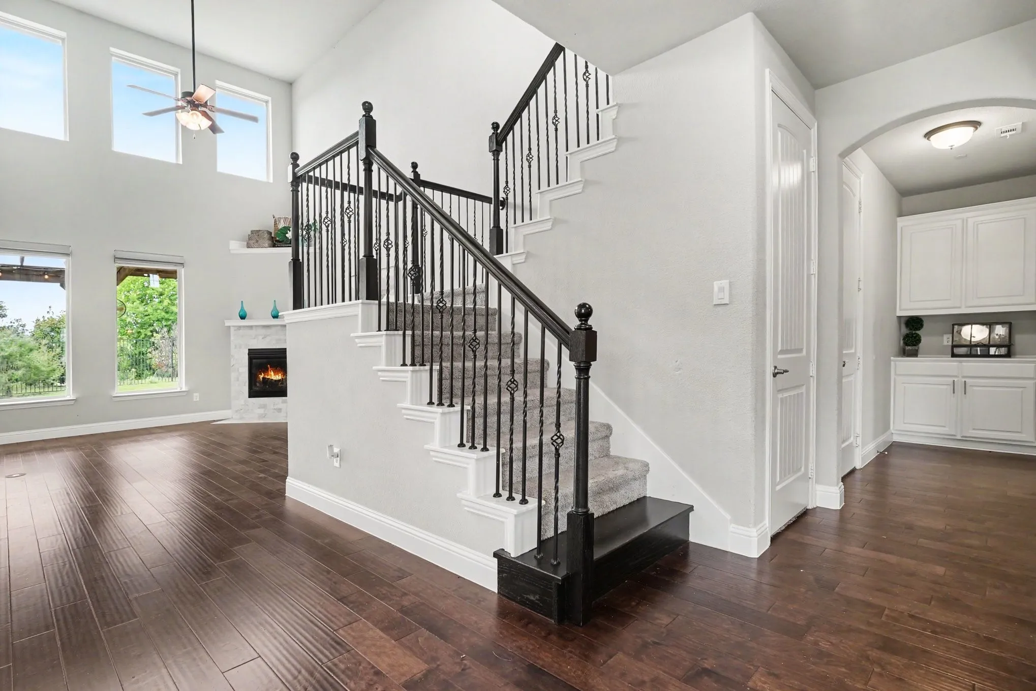 Headed up the staircase featuring wrought iron balusters and carpeted treads