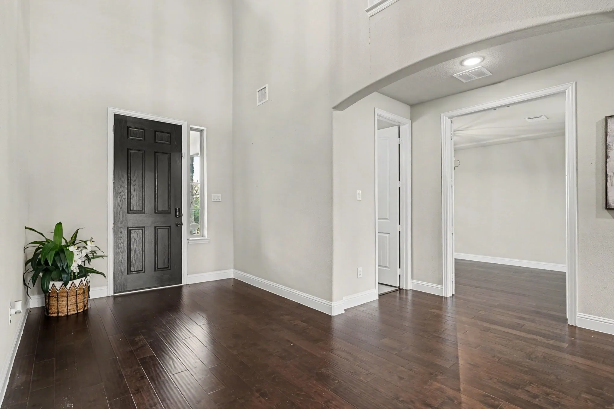 Entrance Foyer featuring wood-finish flooring, a dark paneled front door, an arched doorway, and recessed ceiling lighting