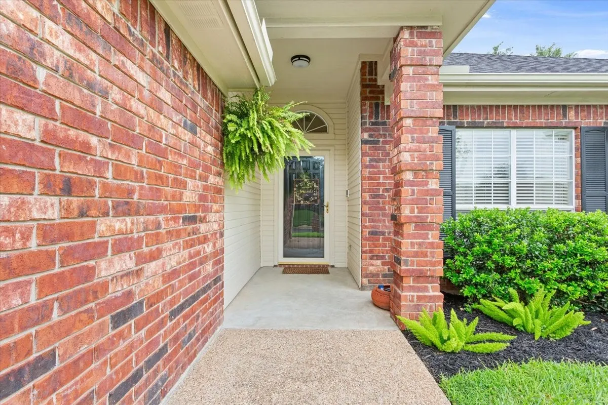 Brick exterior with covered entryway, arched transom window, and a concrete pathway