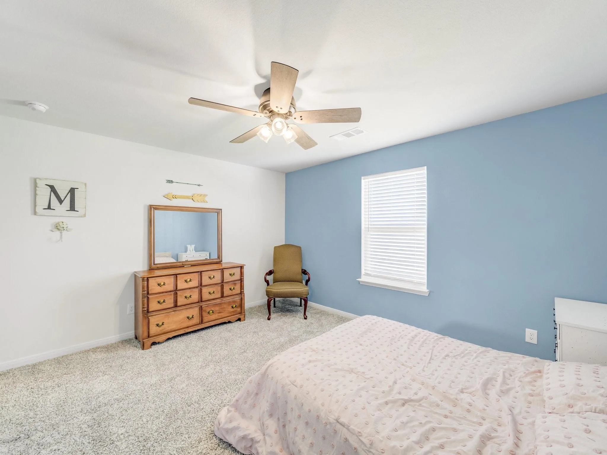 Spacious room featuring light-colored carpet, a ceiling fan with integrated lighting, and a window with blinds