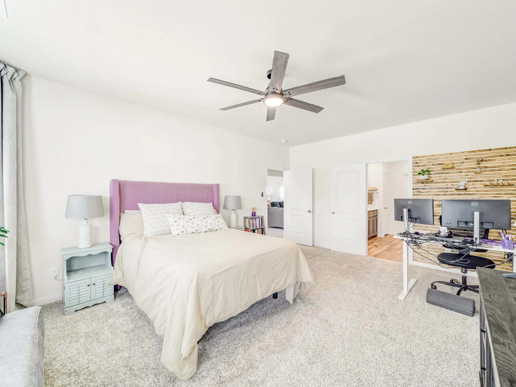 Spacious room featuring vaulted ceilings, a ceiling fan with integrated lighting, plush carpet flooring, and white wall finishes