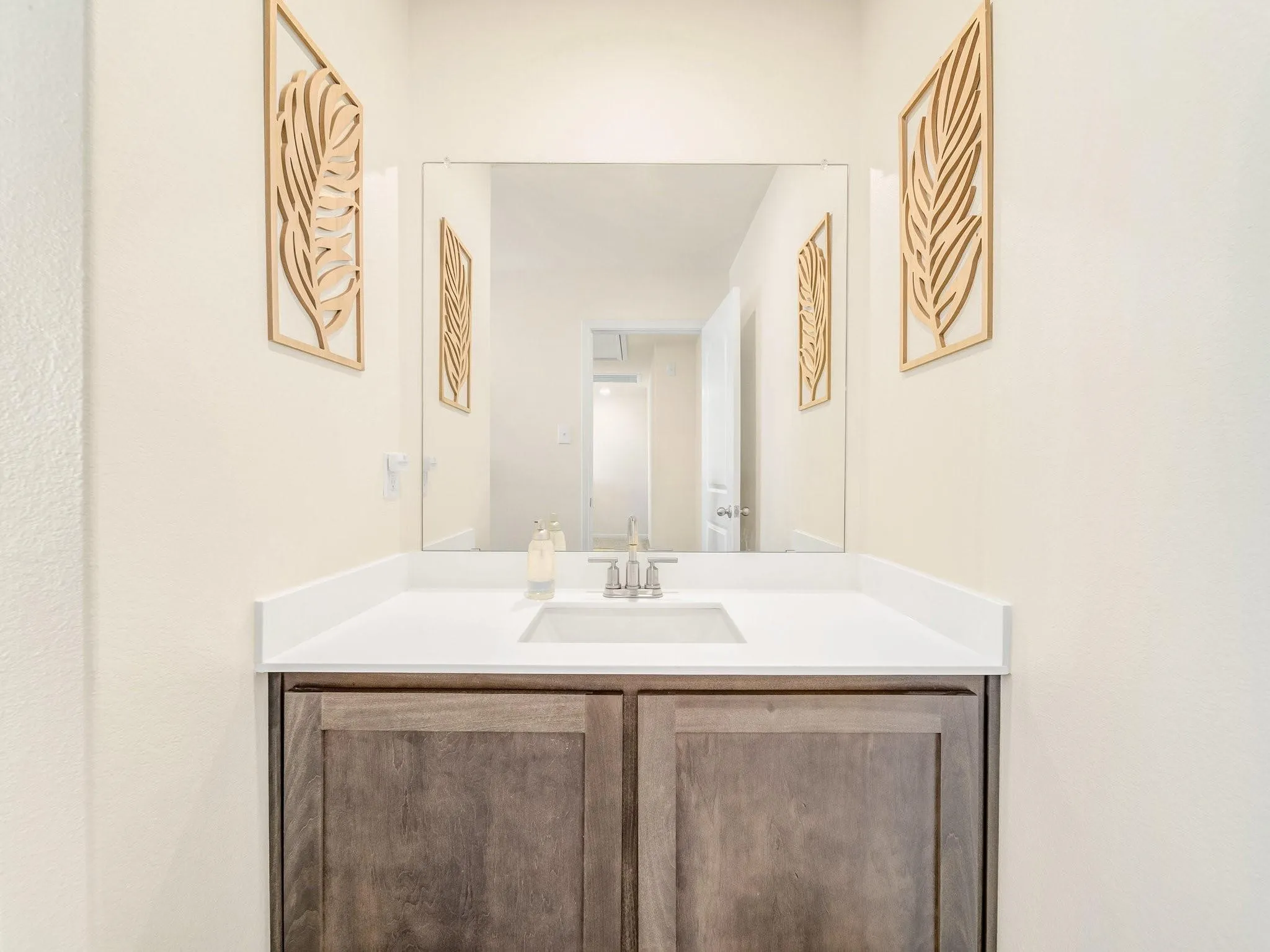 Vanity featuring a rectangular undermount sink, a white countertop, and a chrome faucet