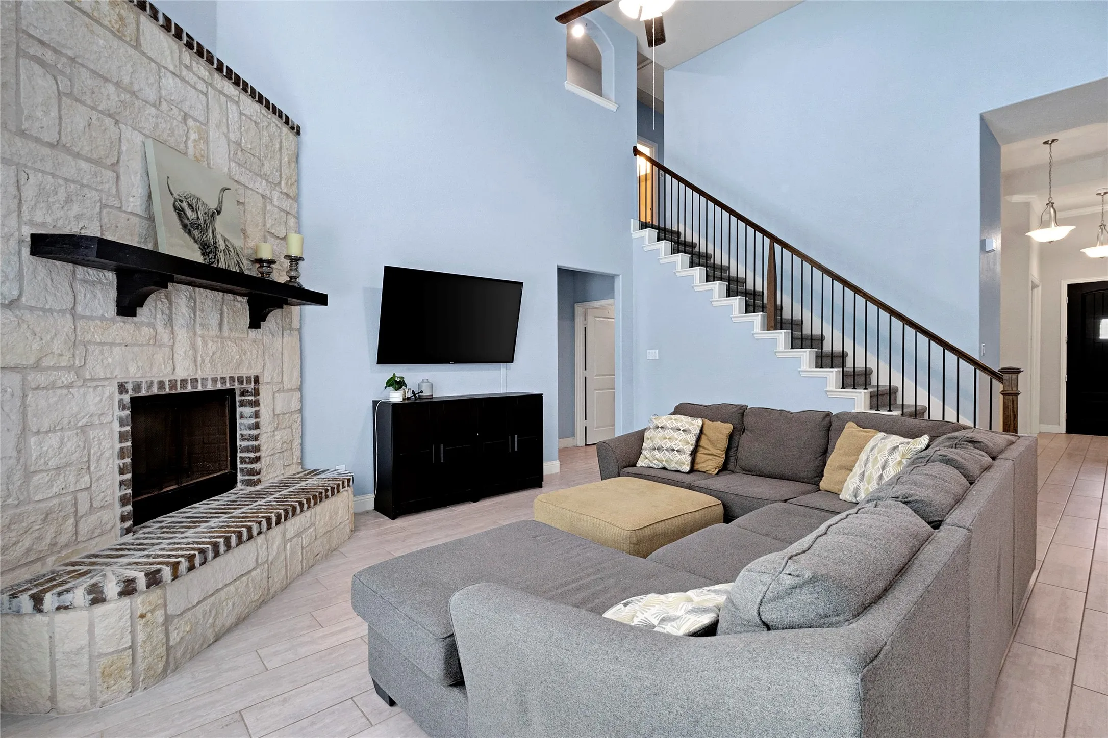 Living area featuring a floor-to-ceiling stone fireplace with a substantial hearth and dark wood mantel
