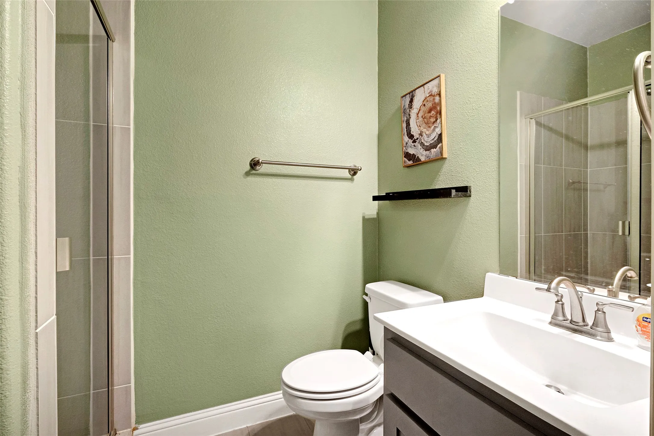 Bathroom featuring a vanity with an integrated sink, dual-handle faucet, and built-in cabinetry