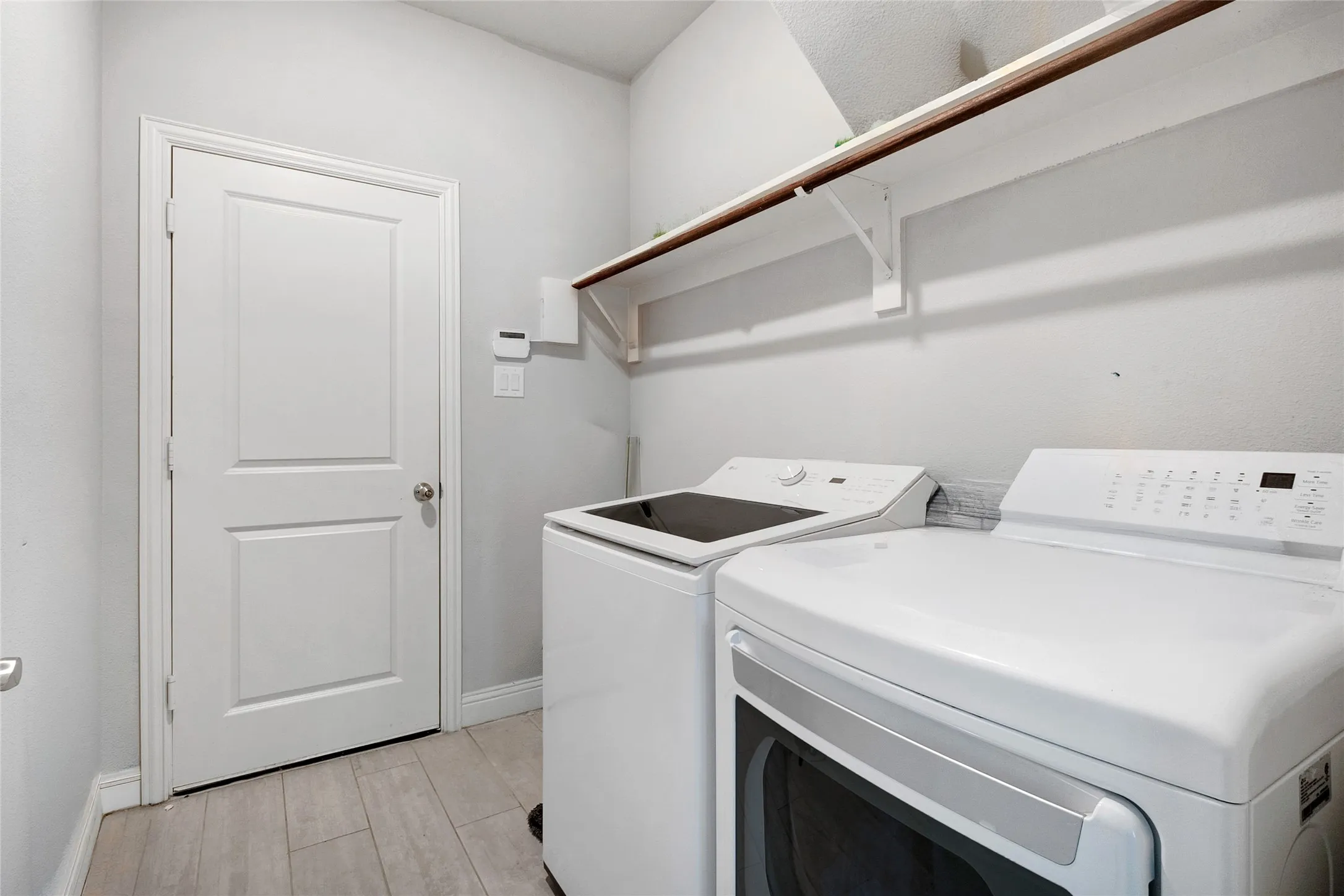 Utility area featuring light wood-finish flooring and a white paneled door