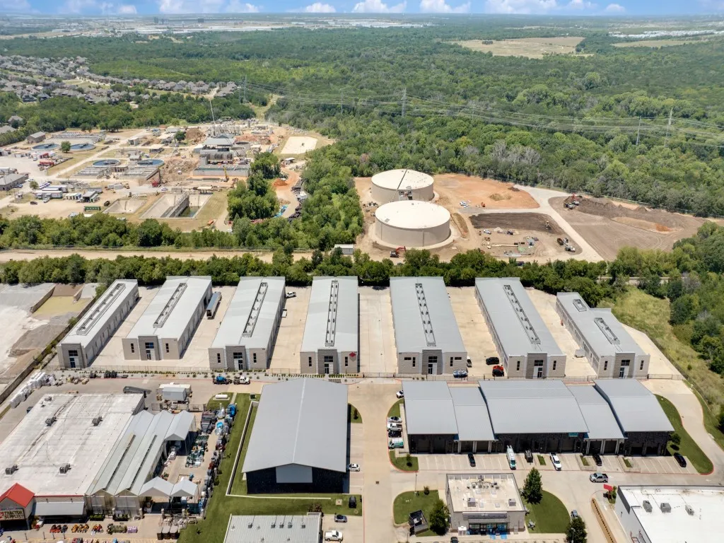Aerial perspective showcasing multiple industrial buildings with gray metal roofs and large parking areas