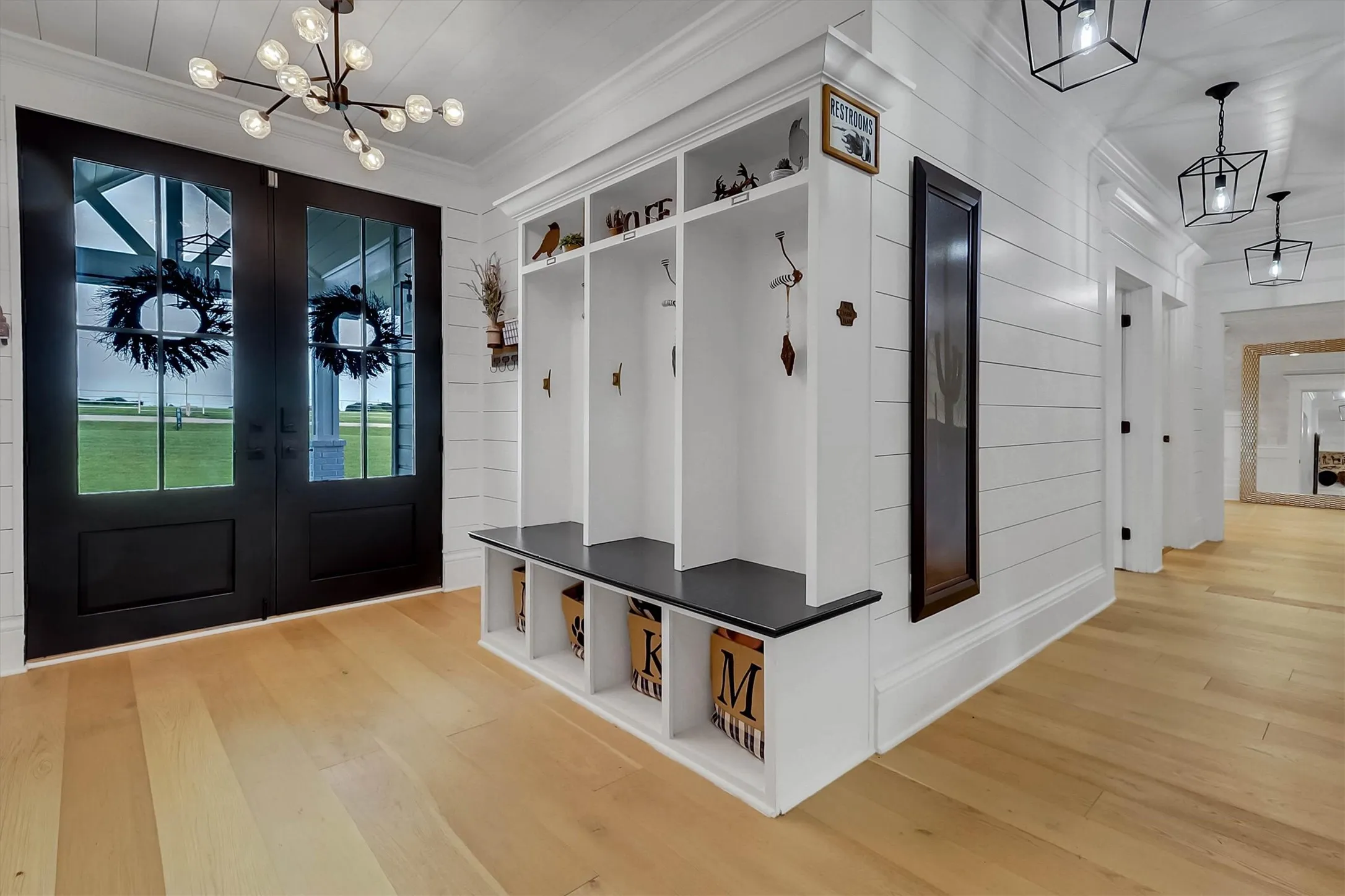 Entryway featuring double French doors, wood-finish flooring, a built-in hall tree with integrated bench, and shiplap wall paneling