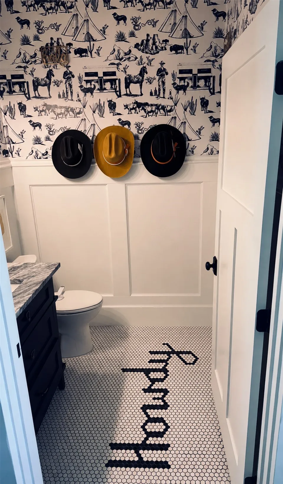 White paneled wainscoting with a patterned wallpaper