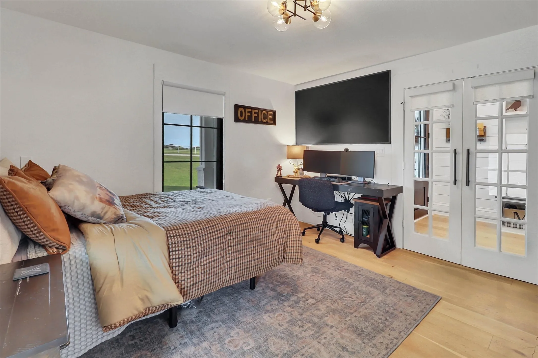 Room featuring light wood-finish flooring and a contemporary overhead light fixture