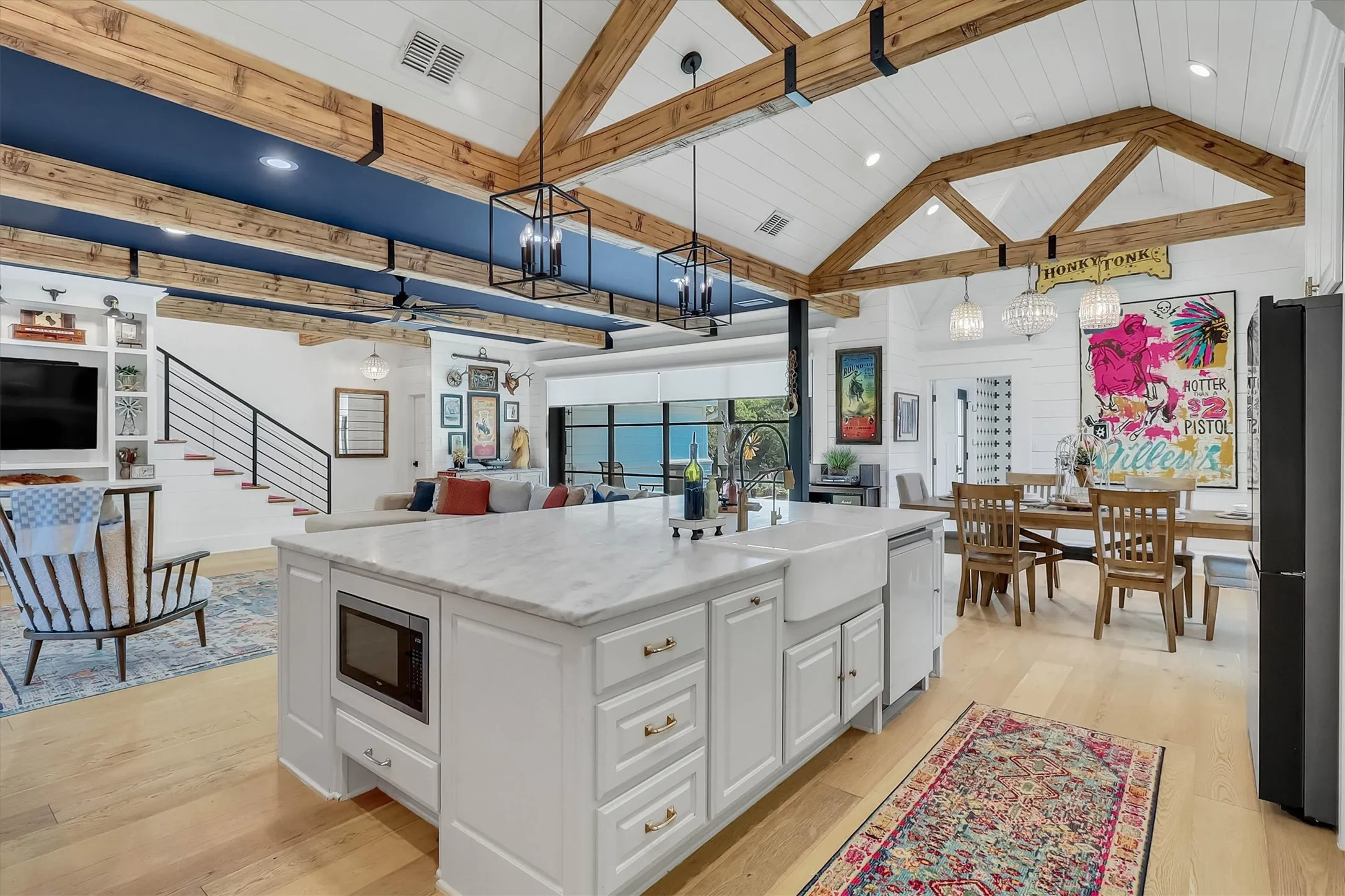 Spacious kitchen island featuring a light-toned countertop, integrated microwave, and farmhouse sink