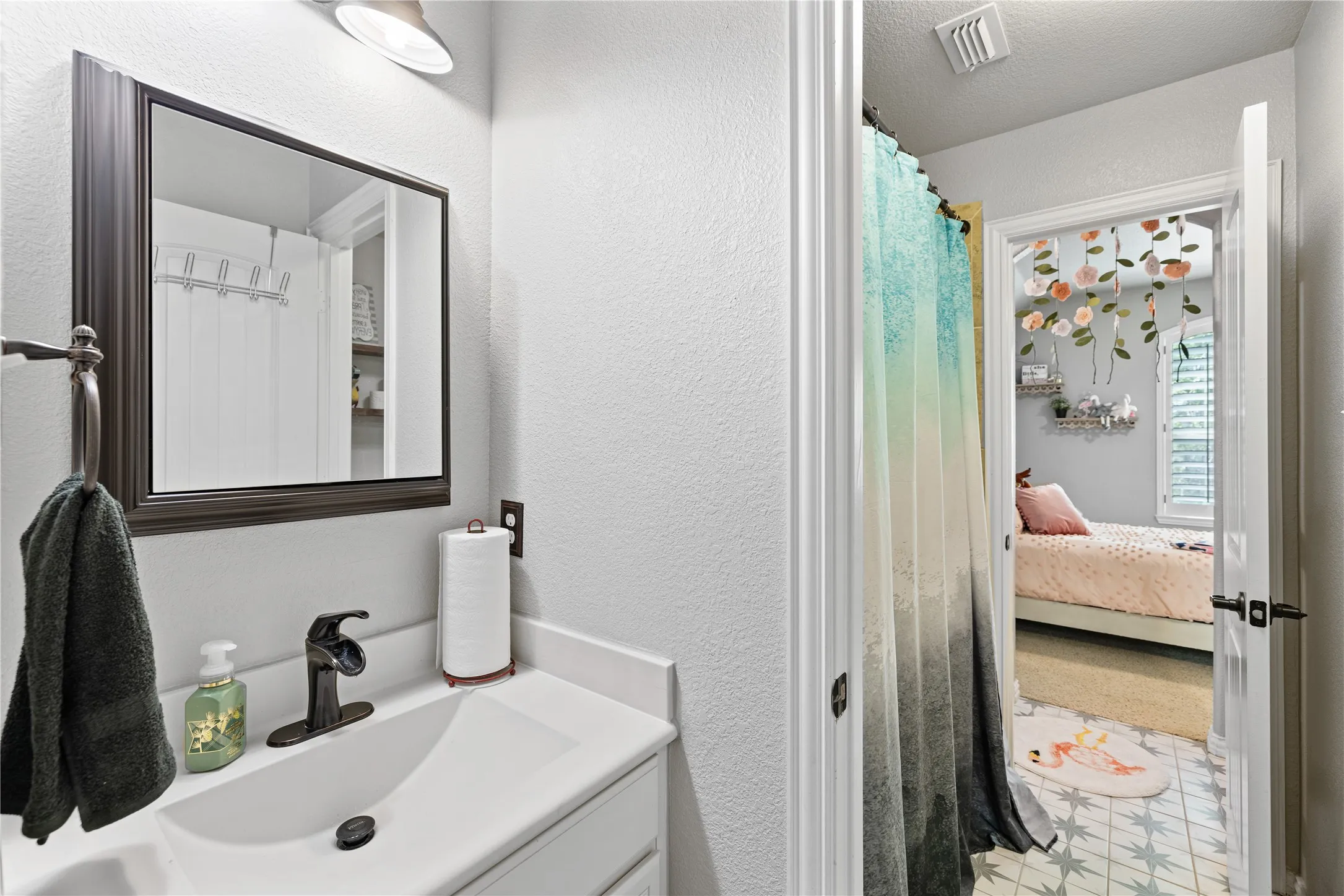 Bathroom featuring tile flooring, vanity, and a textured ceiling