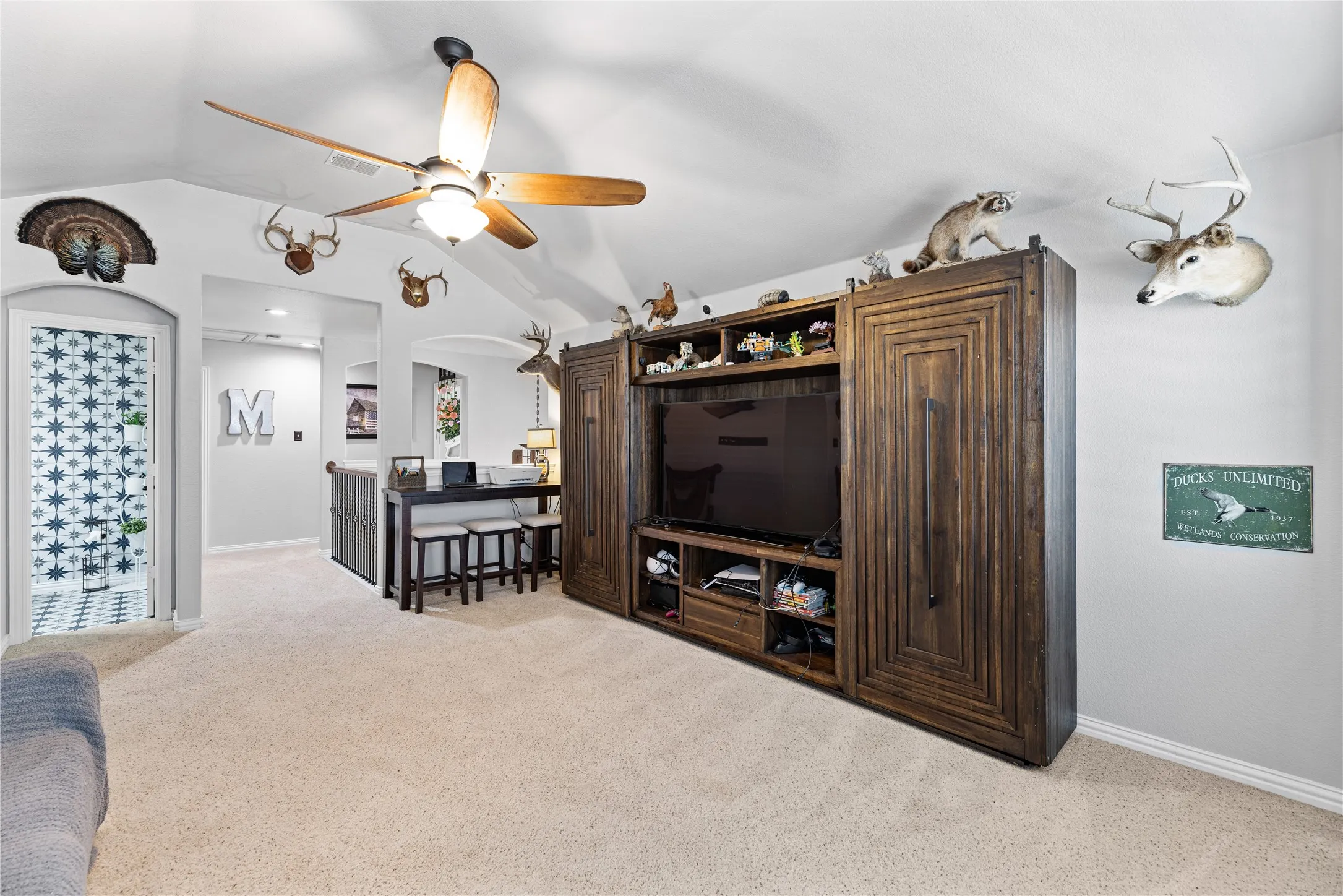 Living room with light carpet, ceiling fan, and lofted ceiling