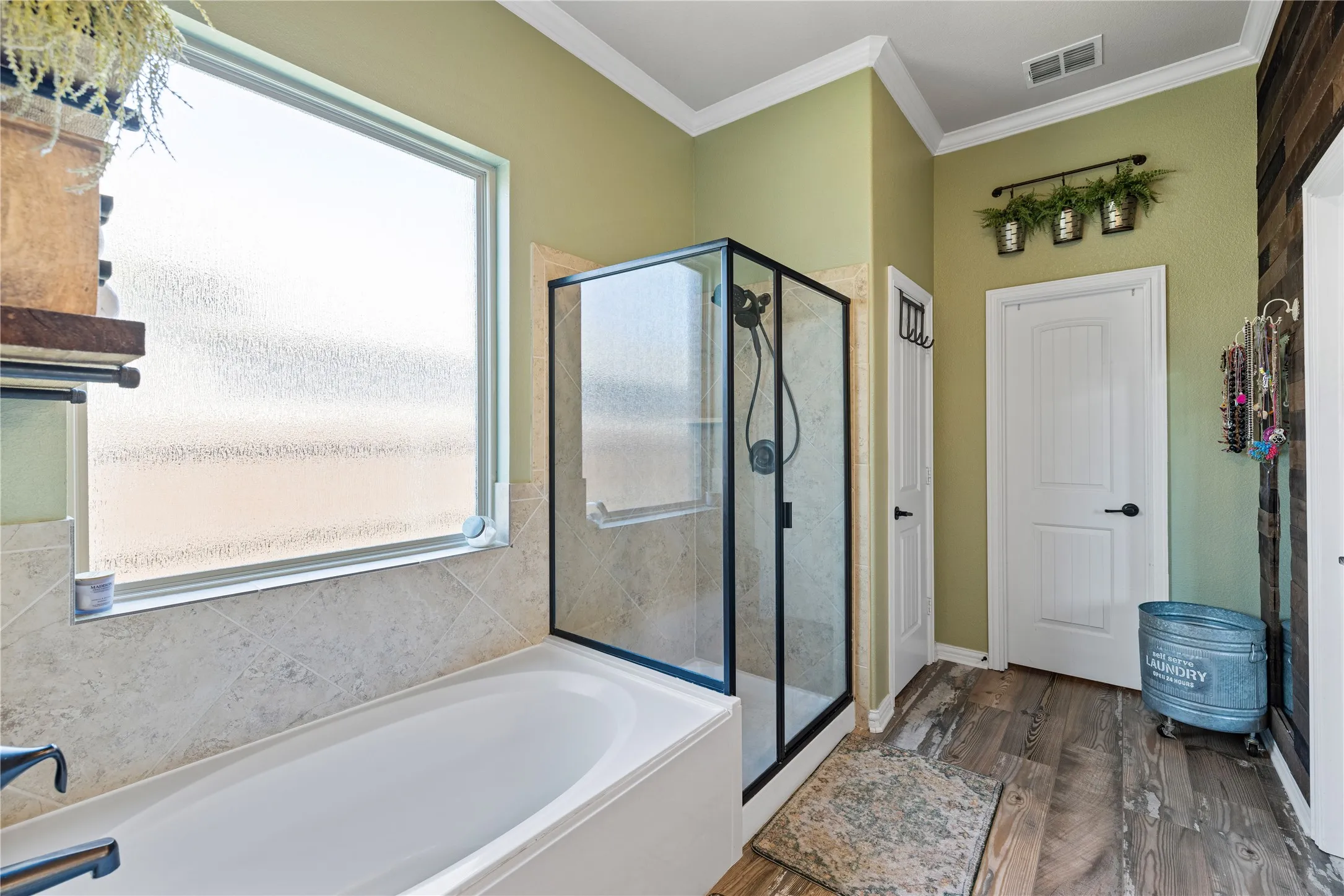 Bathroom with ornamental molding, plenty of natural light, separate shower and tub, and hardwood / wood-style floors