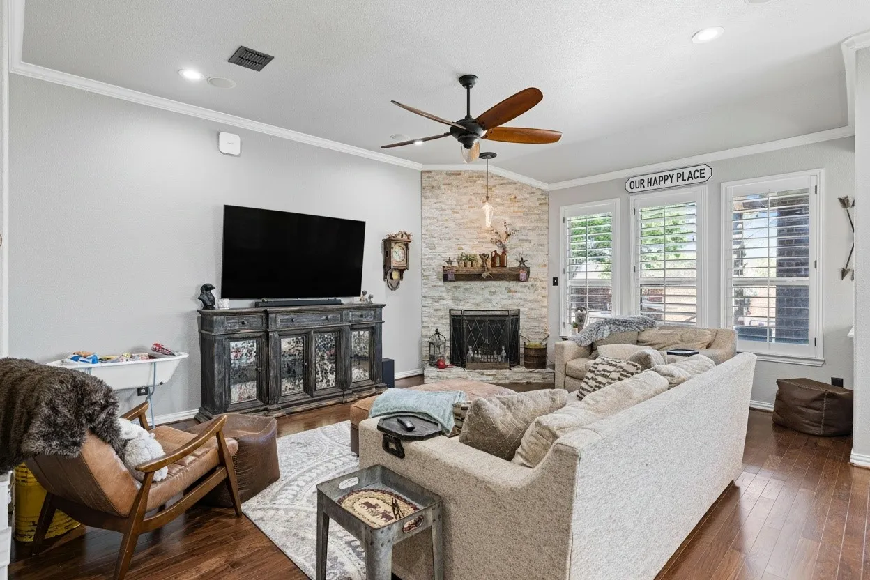 Living area featuring a corner fireplace with a stone surround and wood mantel