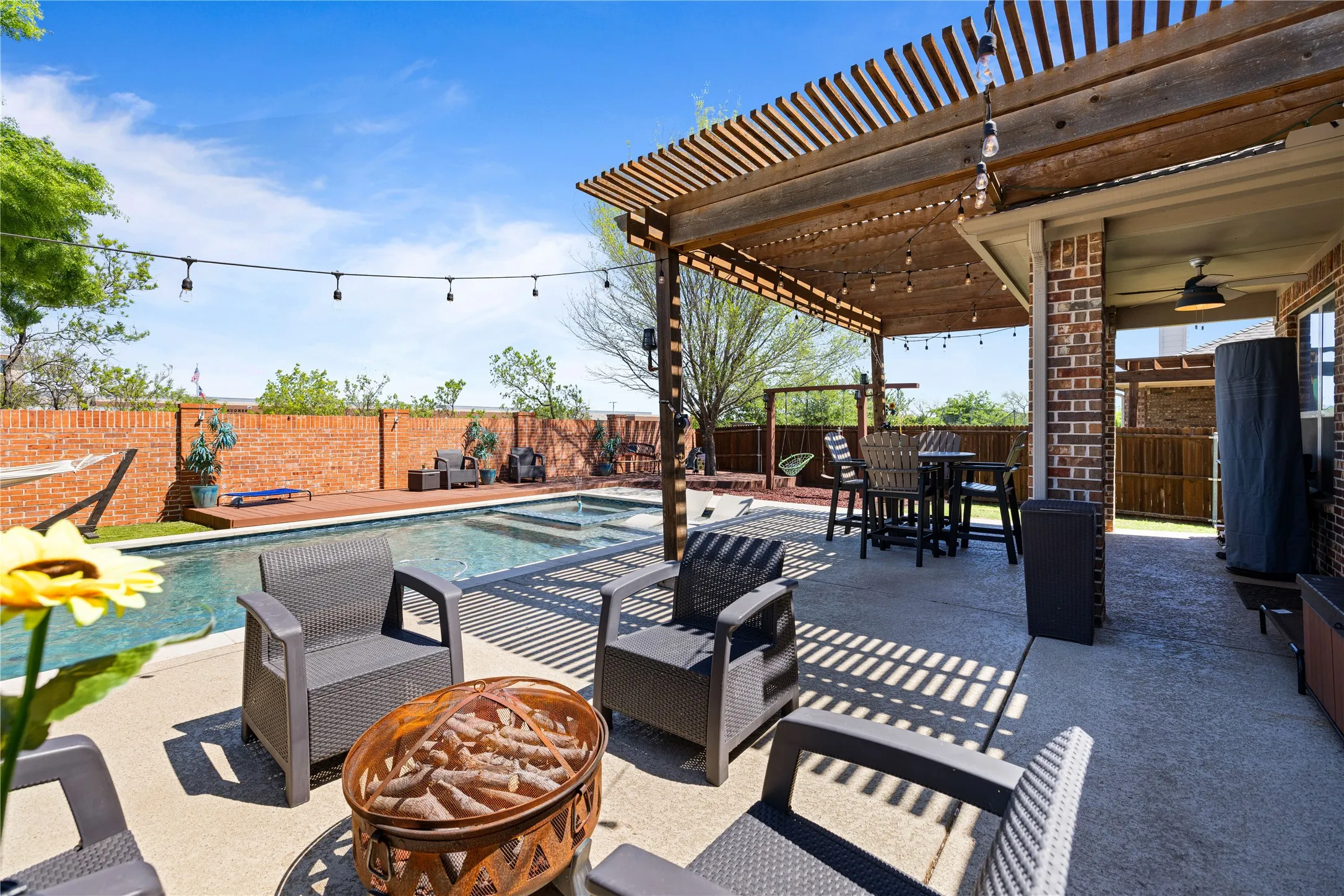 View of patio / terrace with a fenced in pool, ceiling fan, a fire pit, and a pergola